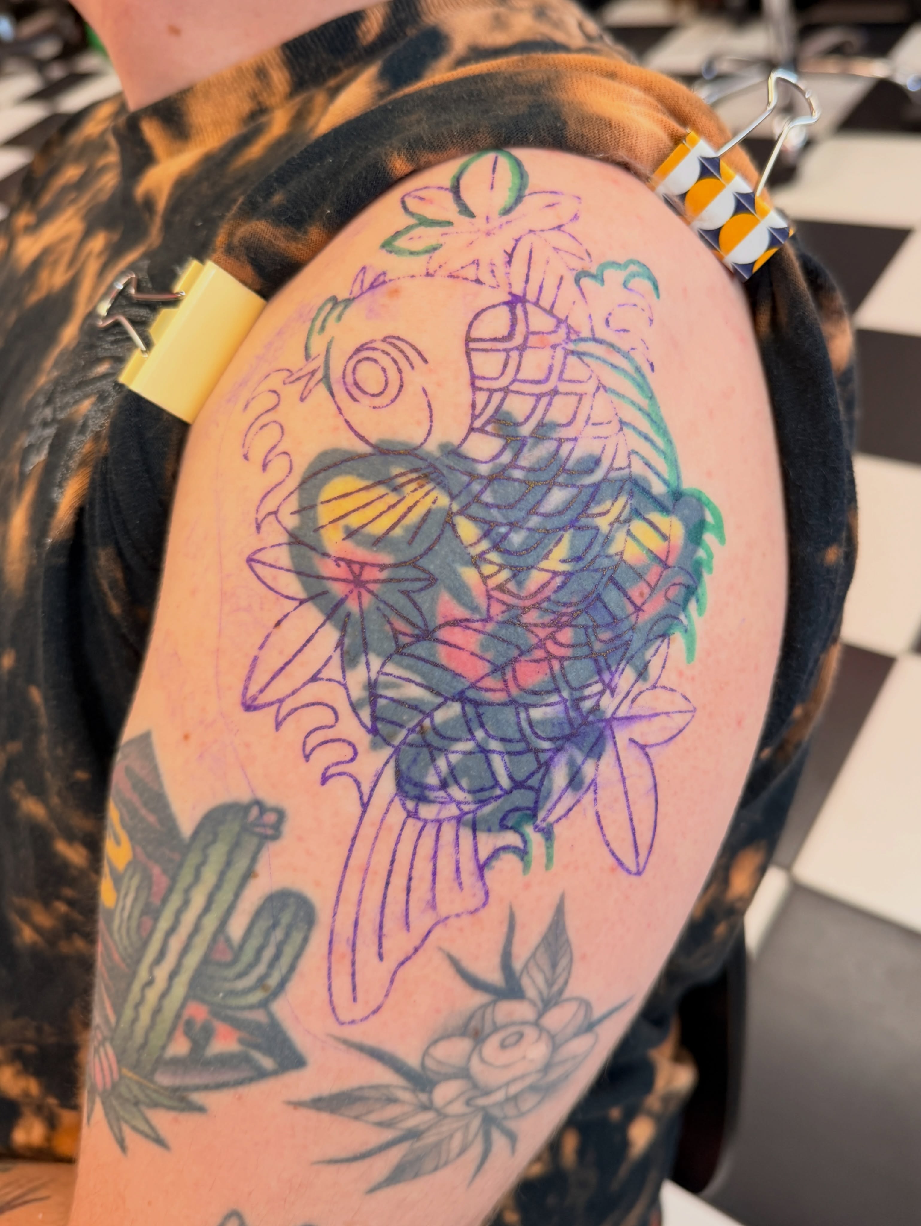 Koi fish American traditional tattoo on the upper arm by Emma Fox Tattoo