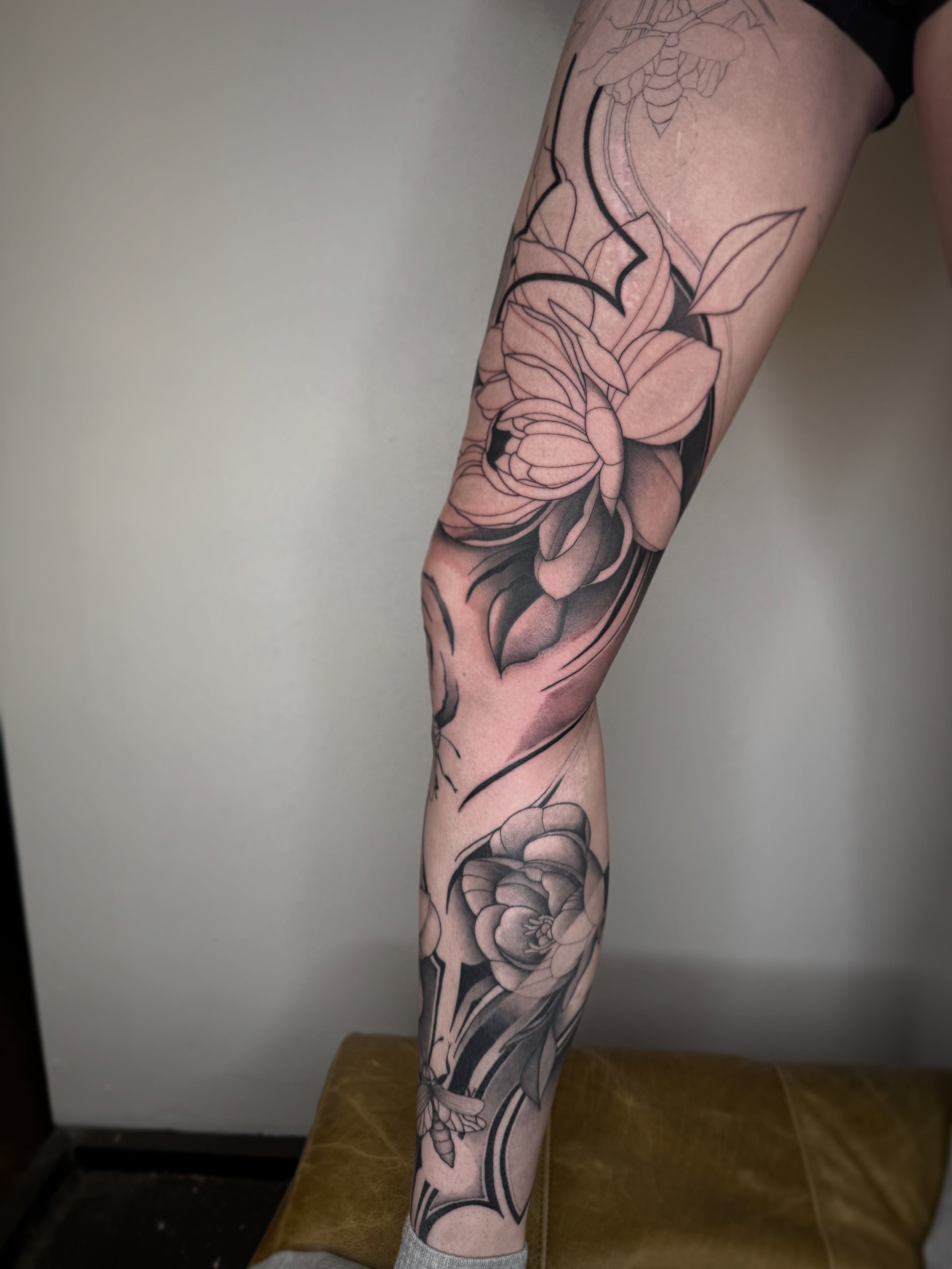 Lotus flowers black and grey tattoo on the calf by Brandon Shelby