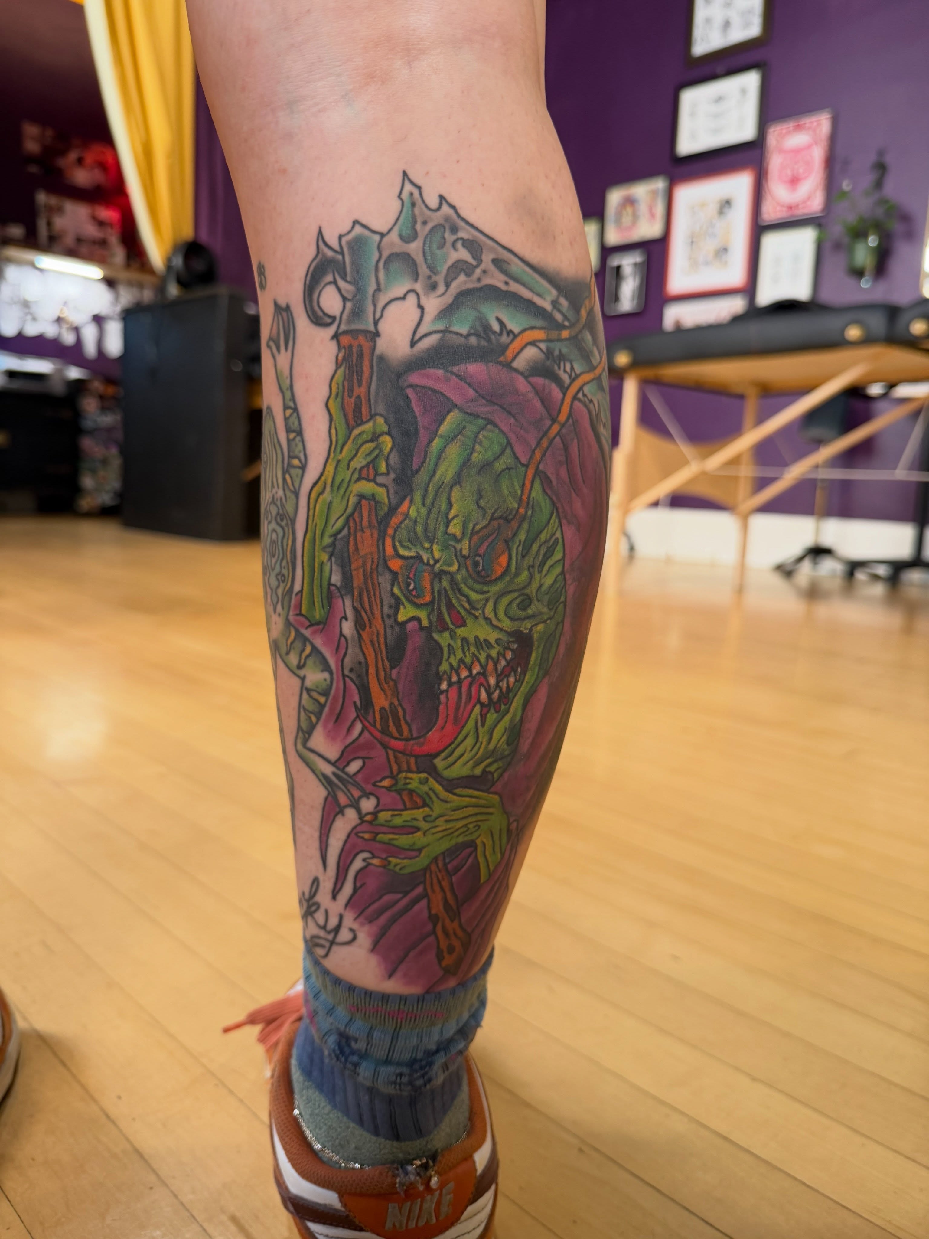 Ghoul with axe dark realism tattoo on the calf by Trevor Berry