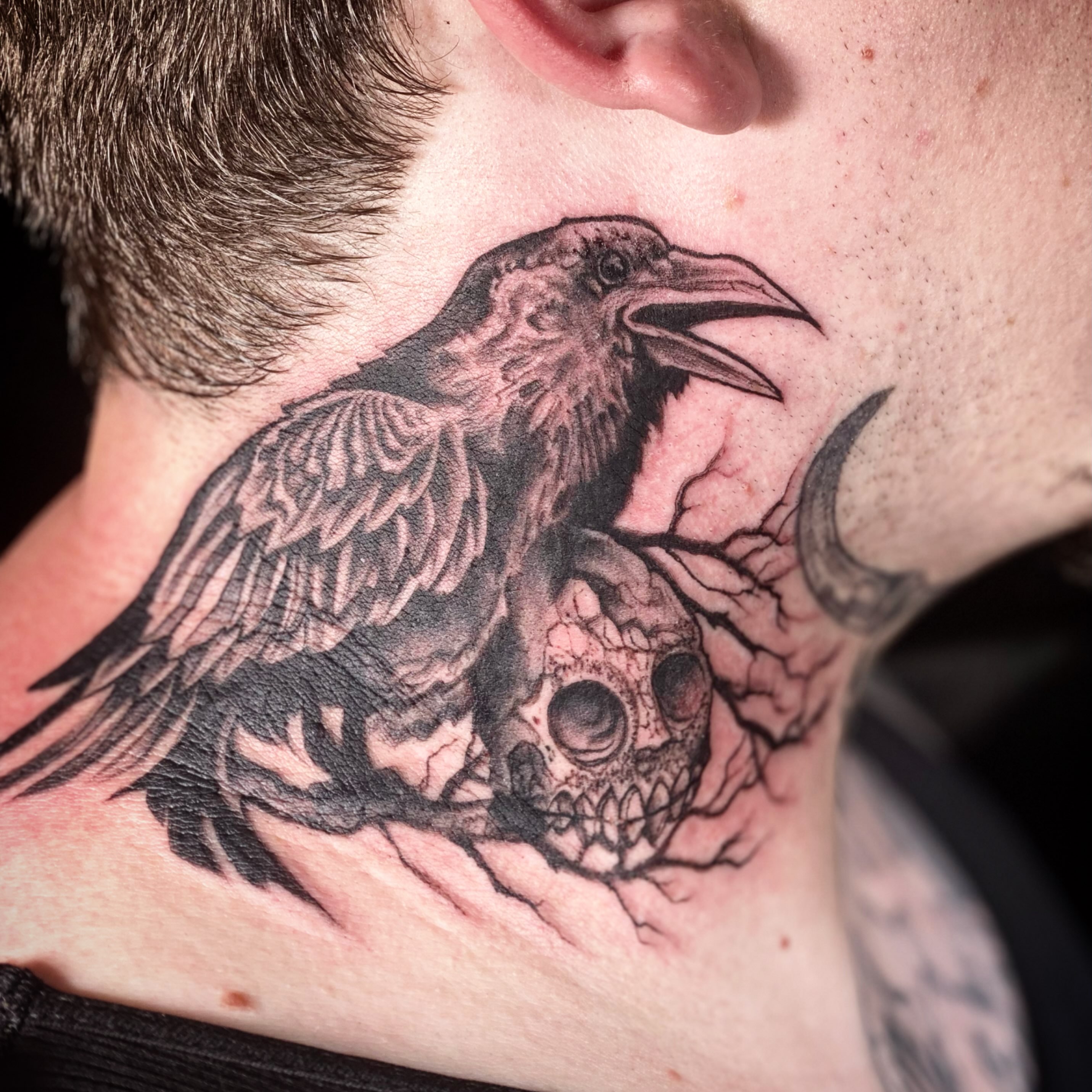 Crow and skull realism tattoo on the neck by Chris Klee