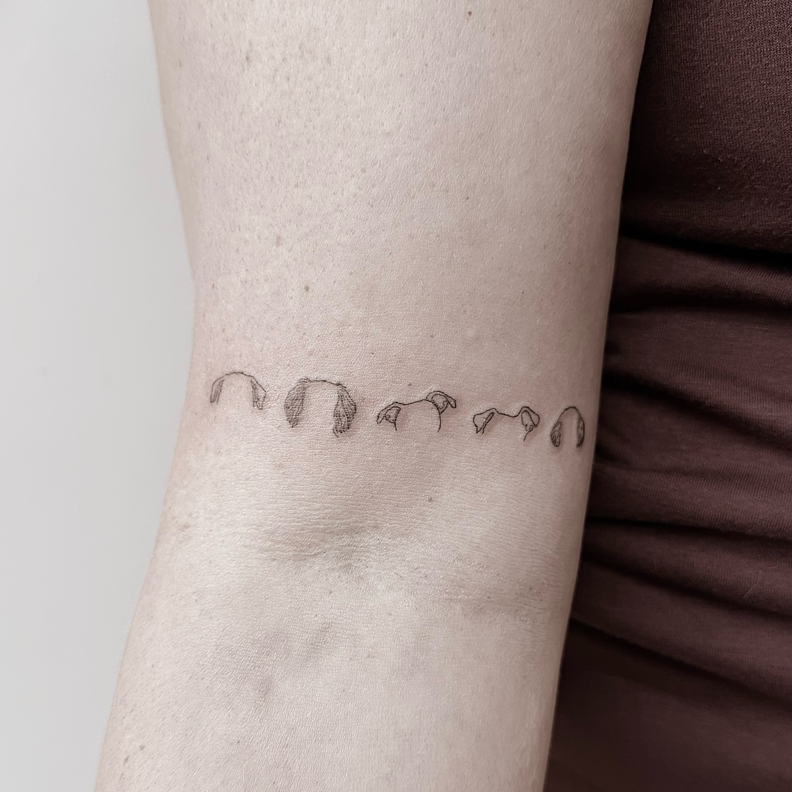 Dogs fine line tattoo on the forearm by Chanel Picquelle, Nashville, Tennessee