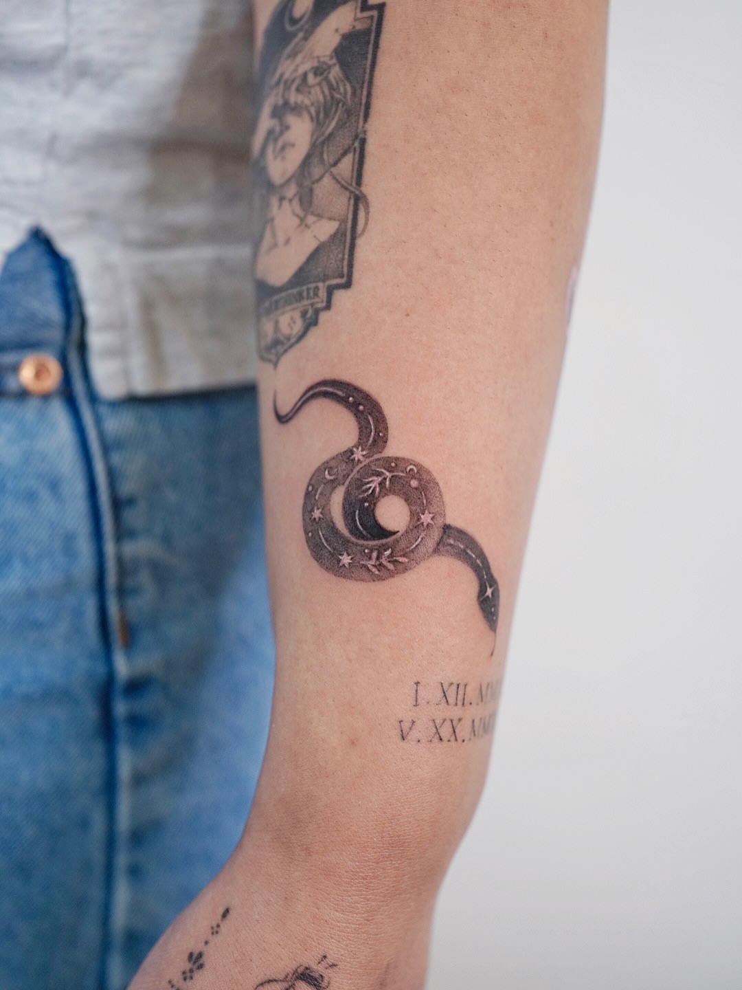 Snake and crescent moon black and grey tattoo on the forearm by Lily, Los Angeles, California