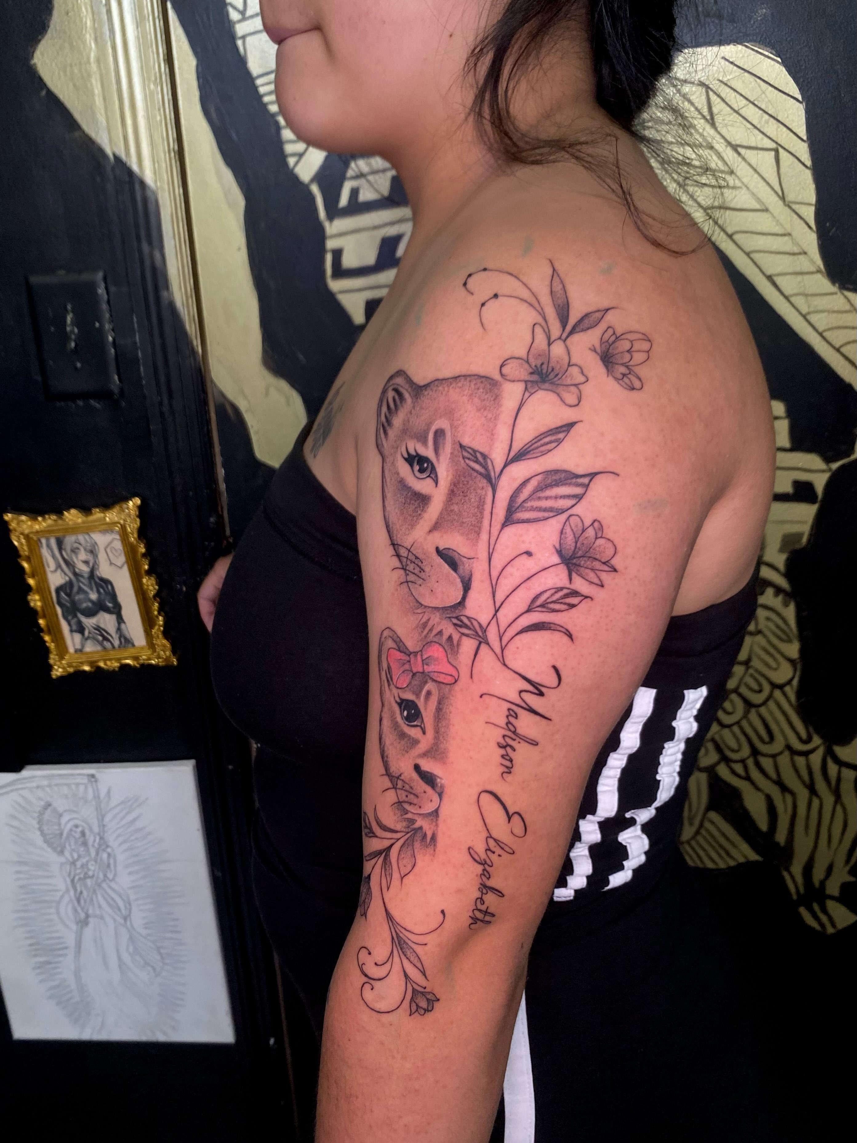 Lioness and cub black and grey tattoo on the upper arm by Irving Guzman