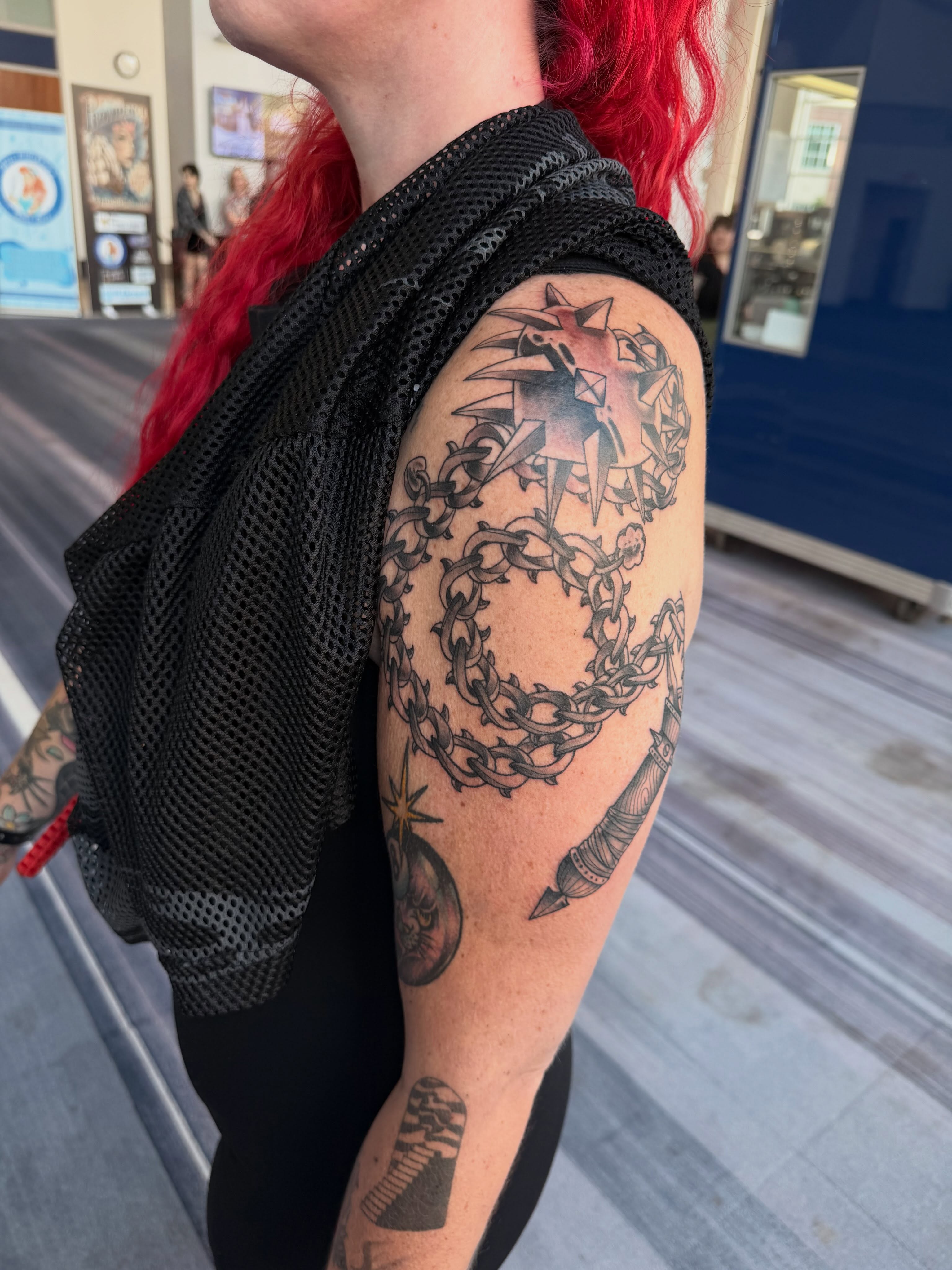 Compass and chains black and grey tattoo on the upper arm by Mika Clairissa