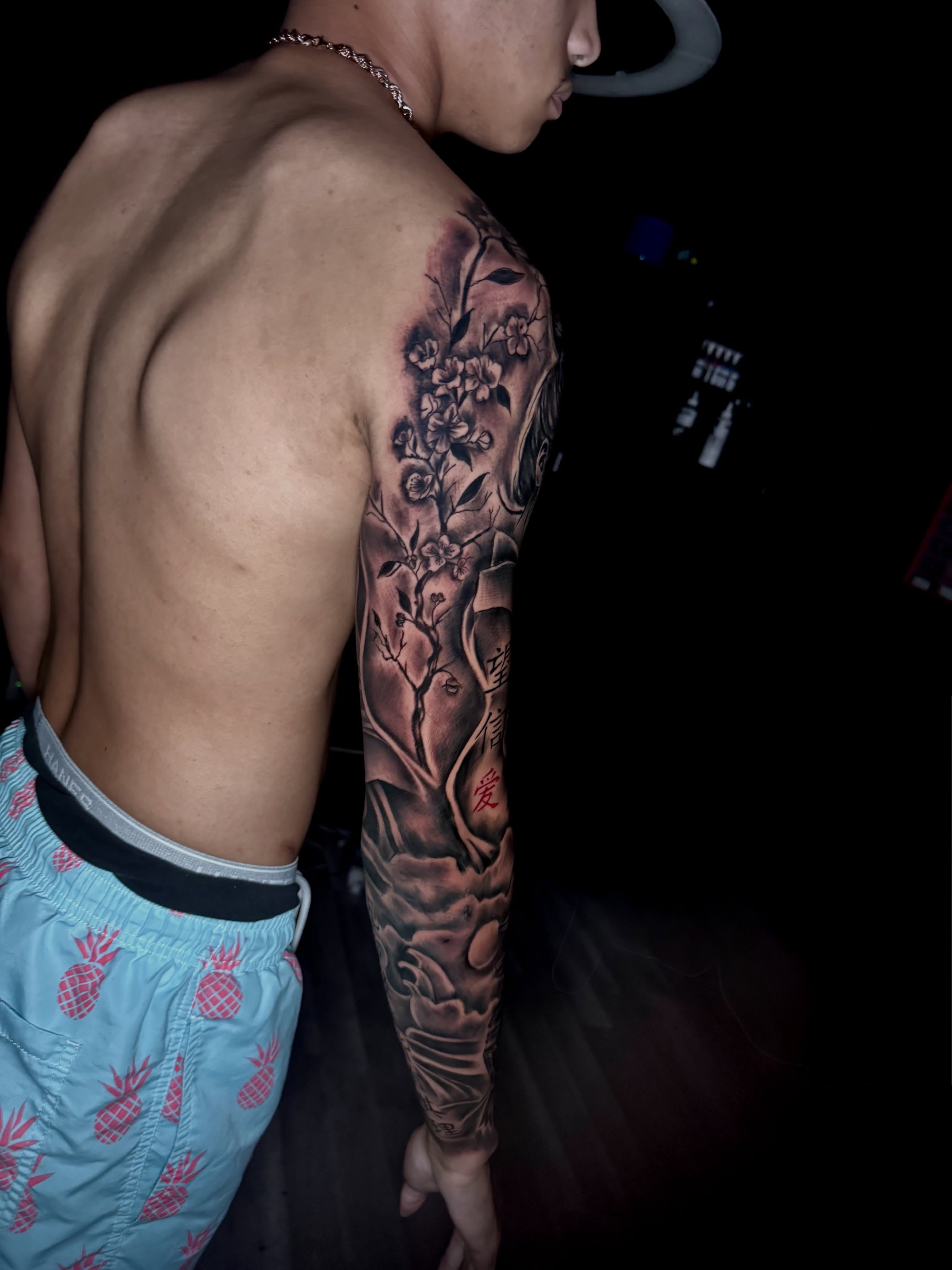 Cherry blossoms realism tattoo on the upper arm by Zeus