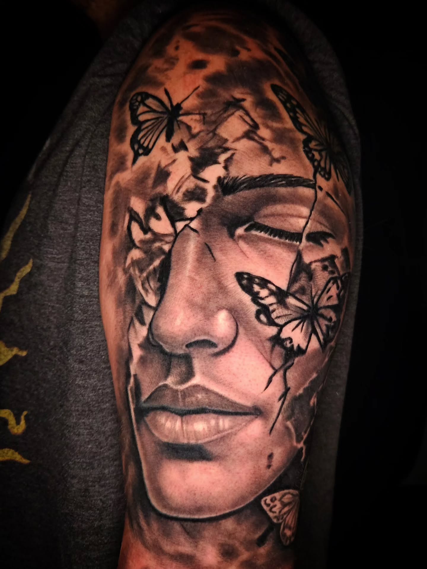 Portrait realism tattoo on the upper arm by Mike Bugenhagen