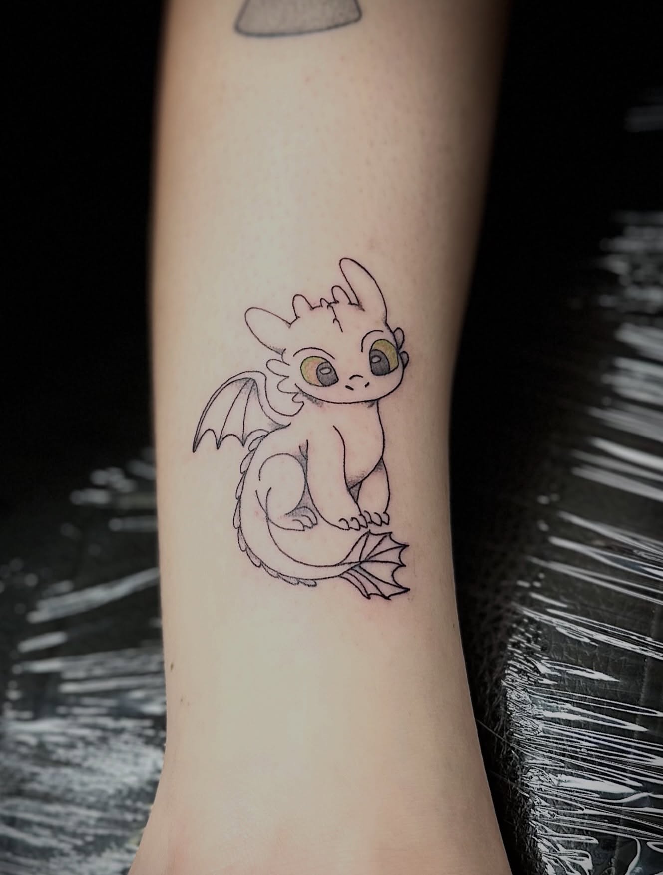 Chibi dragon minimalist tattoo on the forearm by NuNu