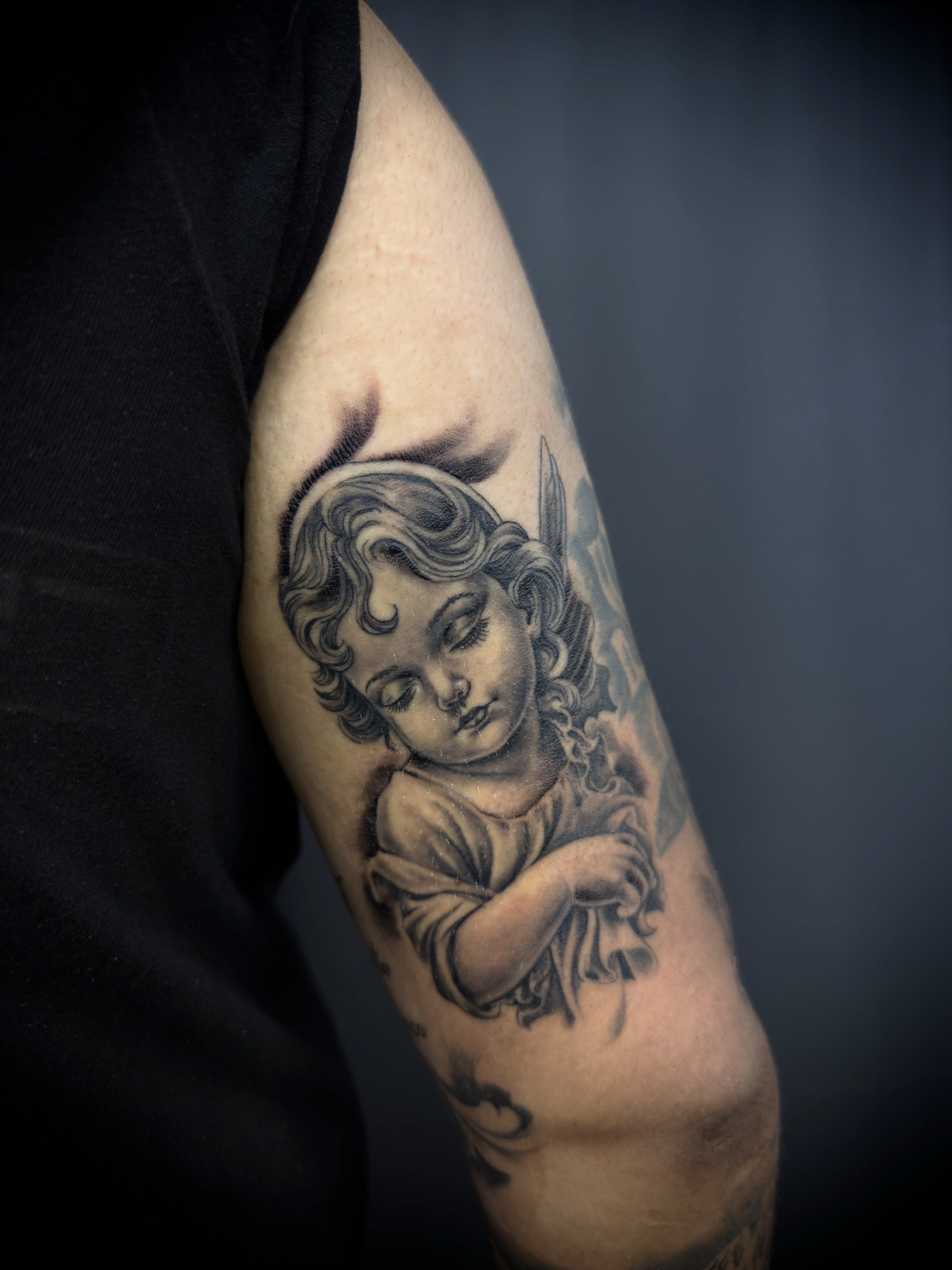 Cherub black and grey tattoo on the forearm by Chuy E ⚡️