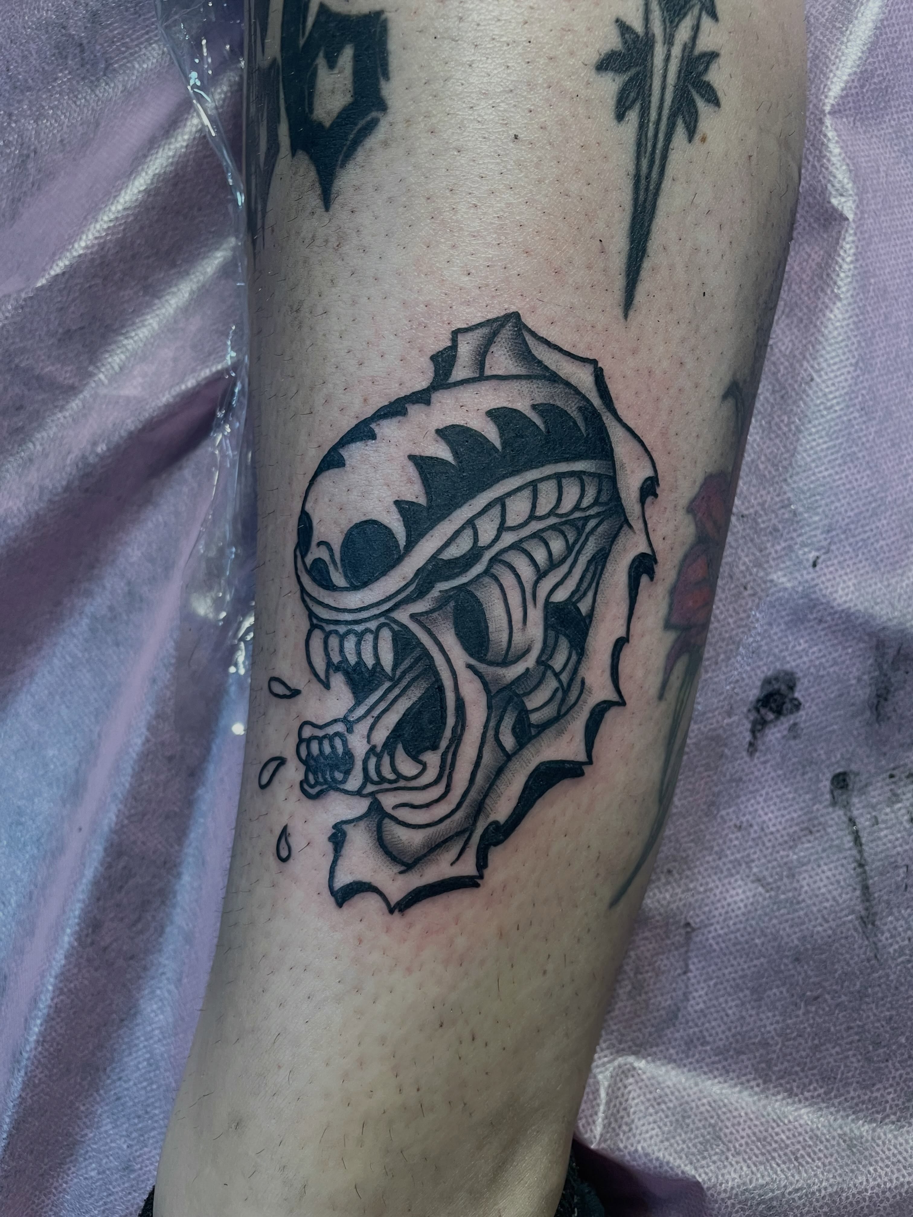 Alien head black and grey tattoo on the forearm by Kaylee 🗡️
