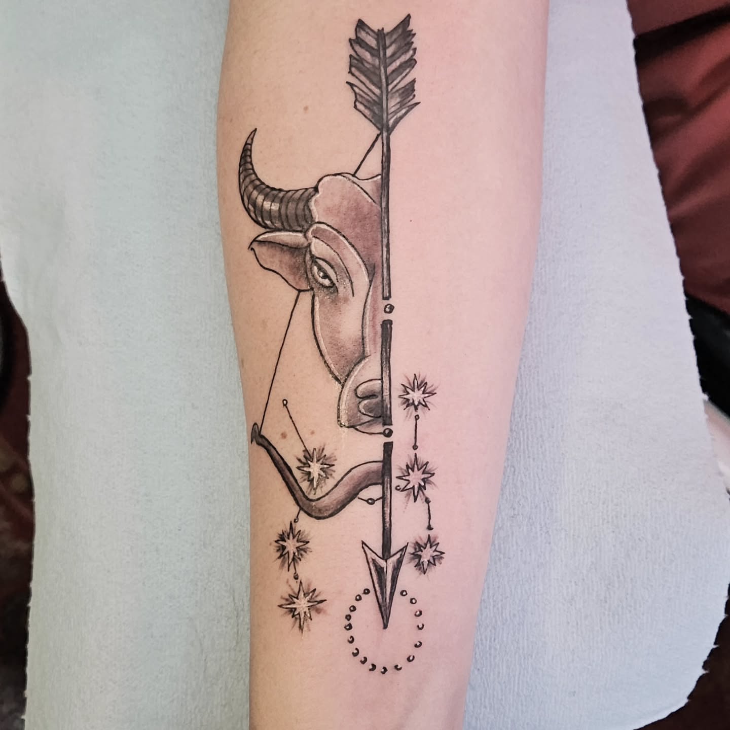 Bull and arrow geometric tattoo on the forearm by Shane Watkins
