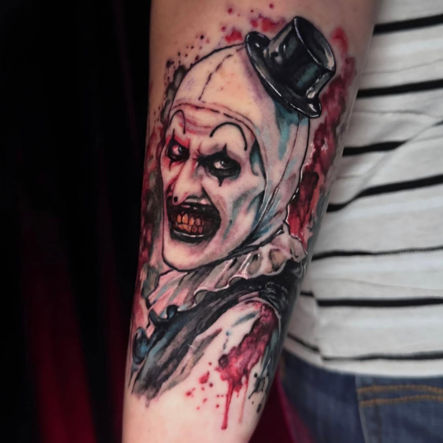 Clown dark realism tattoo on the forearm by Sideshow Danny