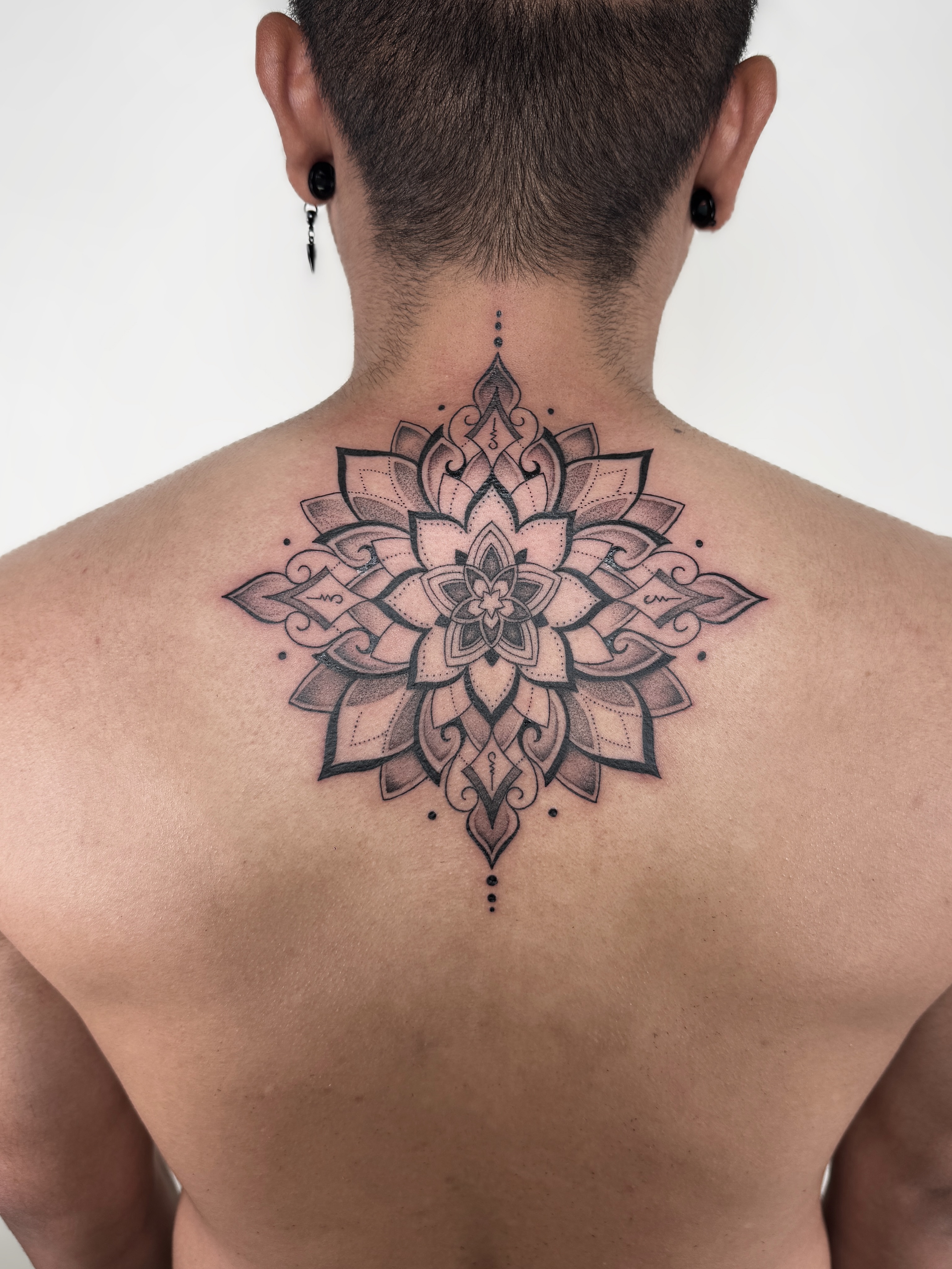 Lotus flower dotwork tattoo on the back by Jadyn Pang