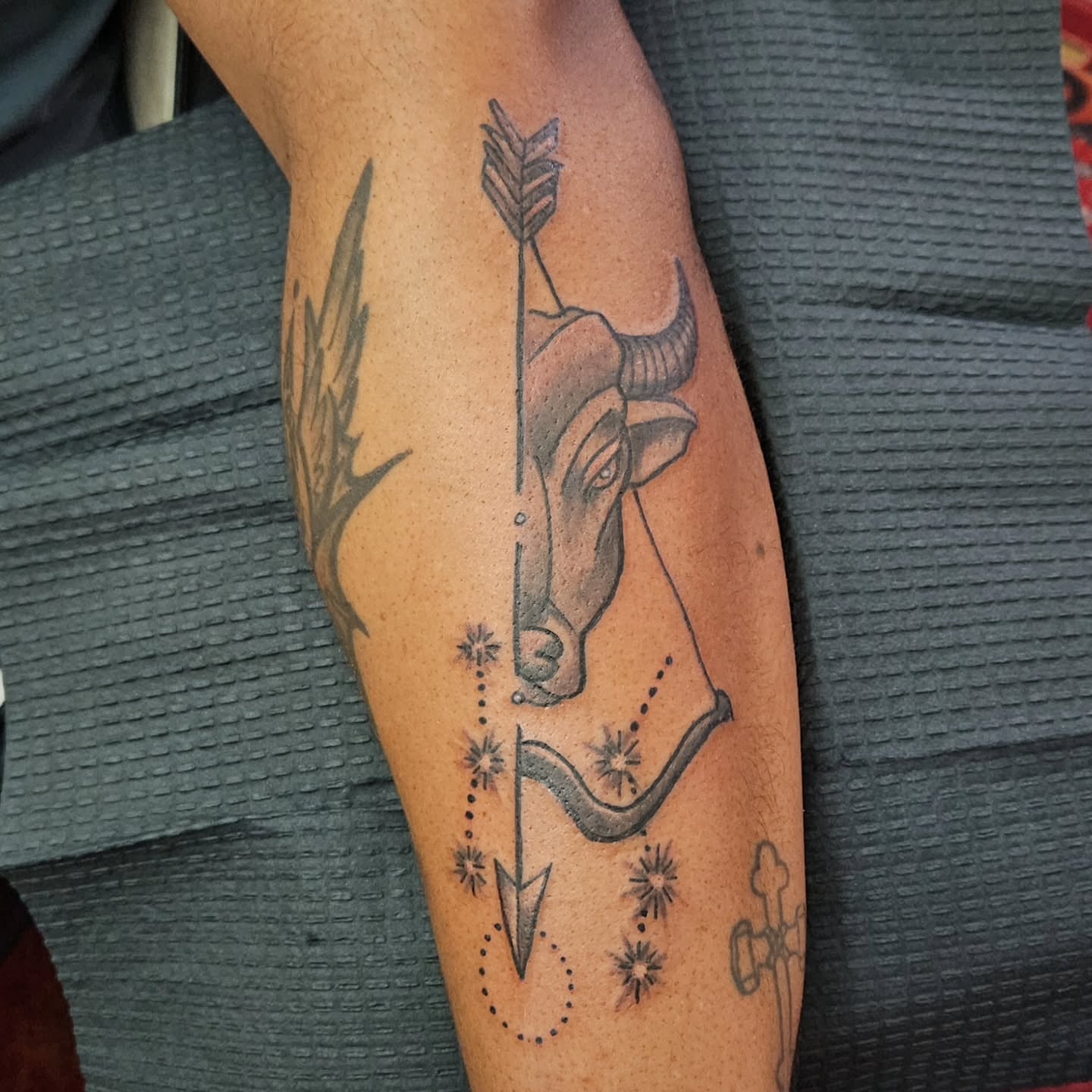 Bull head with arrow geometric tattoo on the forearm by Shane Watkins
