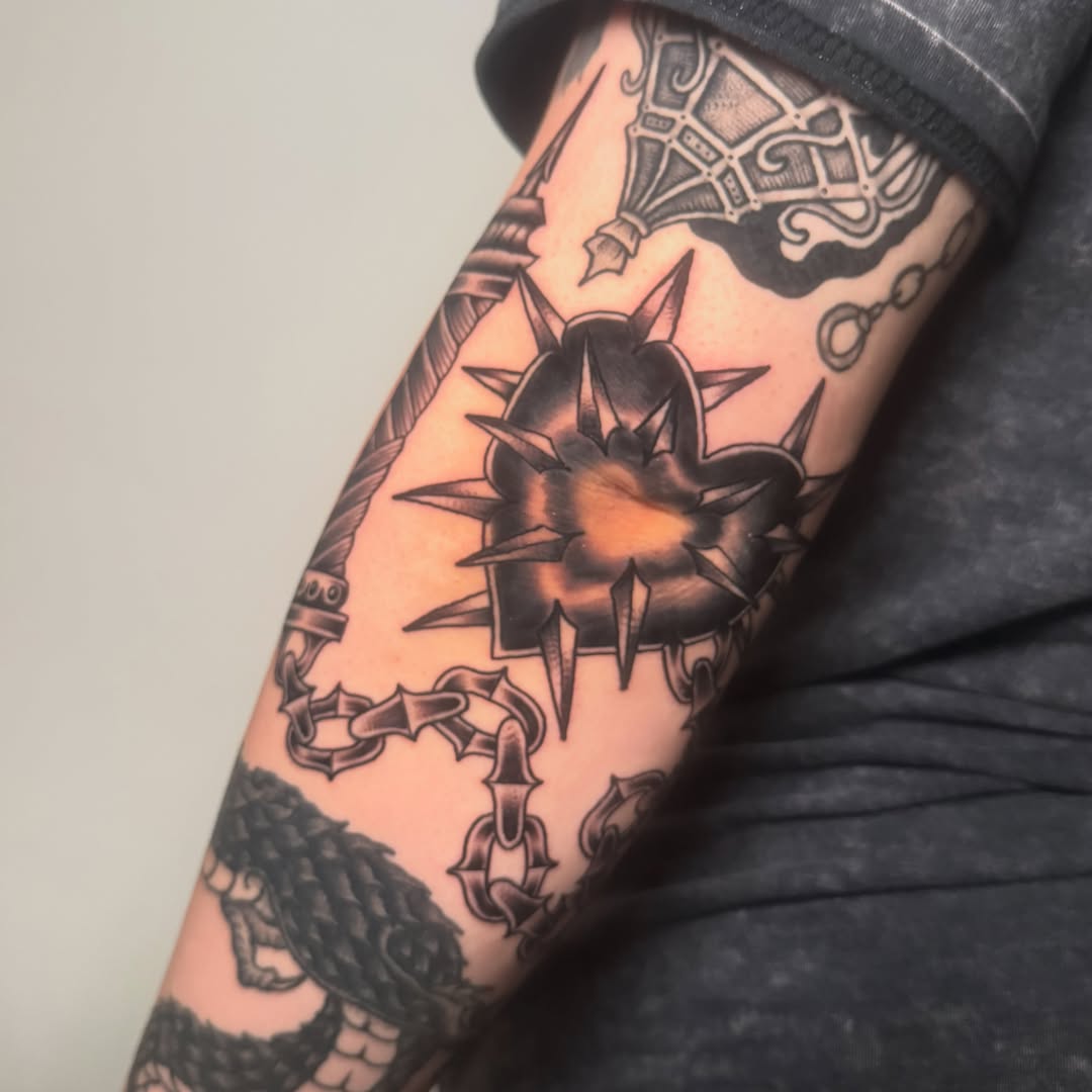 Spiked heart black and grey tattoo on the forearm by Zac Chaffin