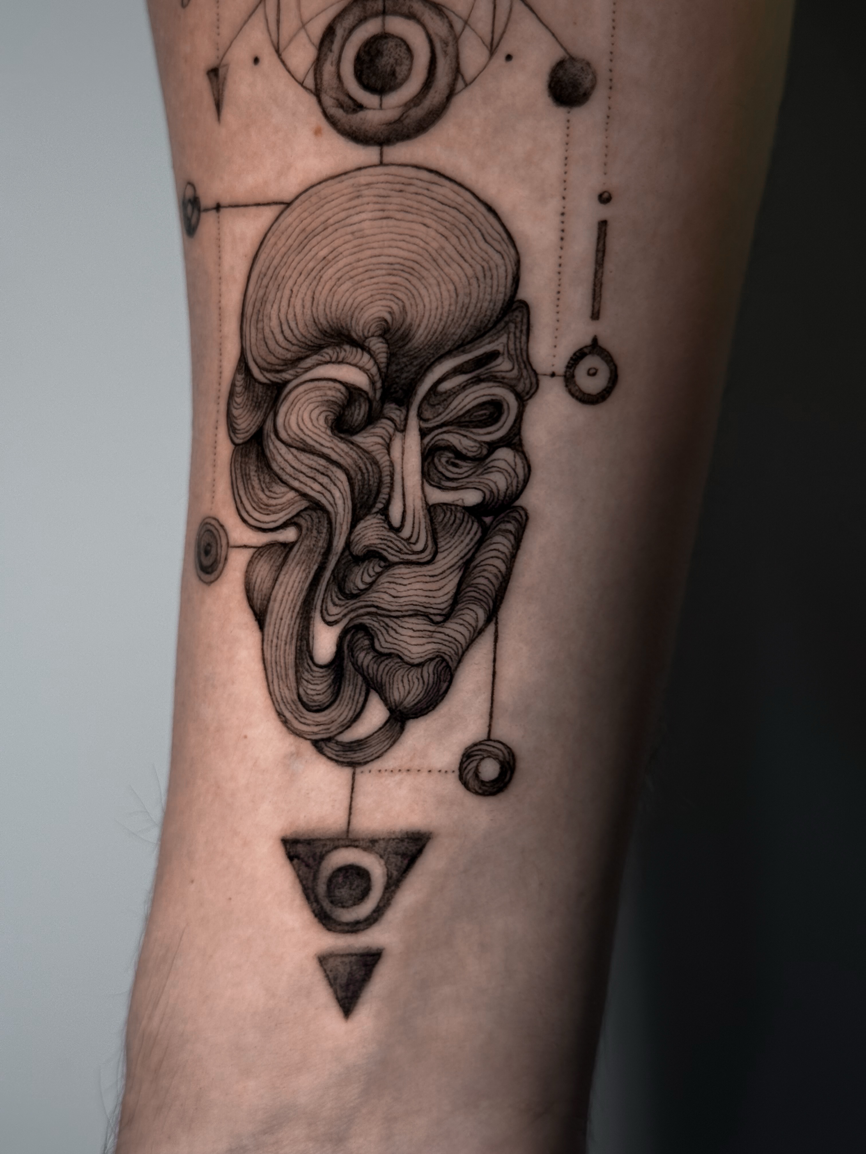 Abstract face geometric tattoo on the forearm by Lily K.