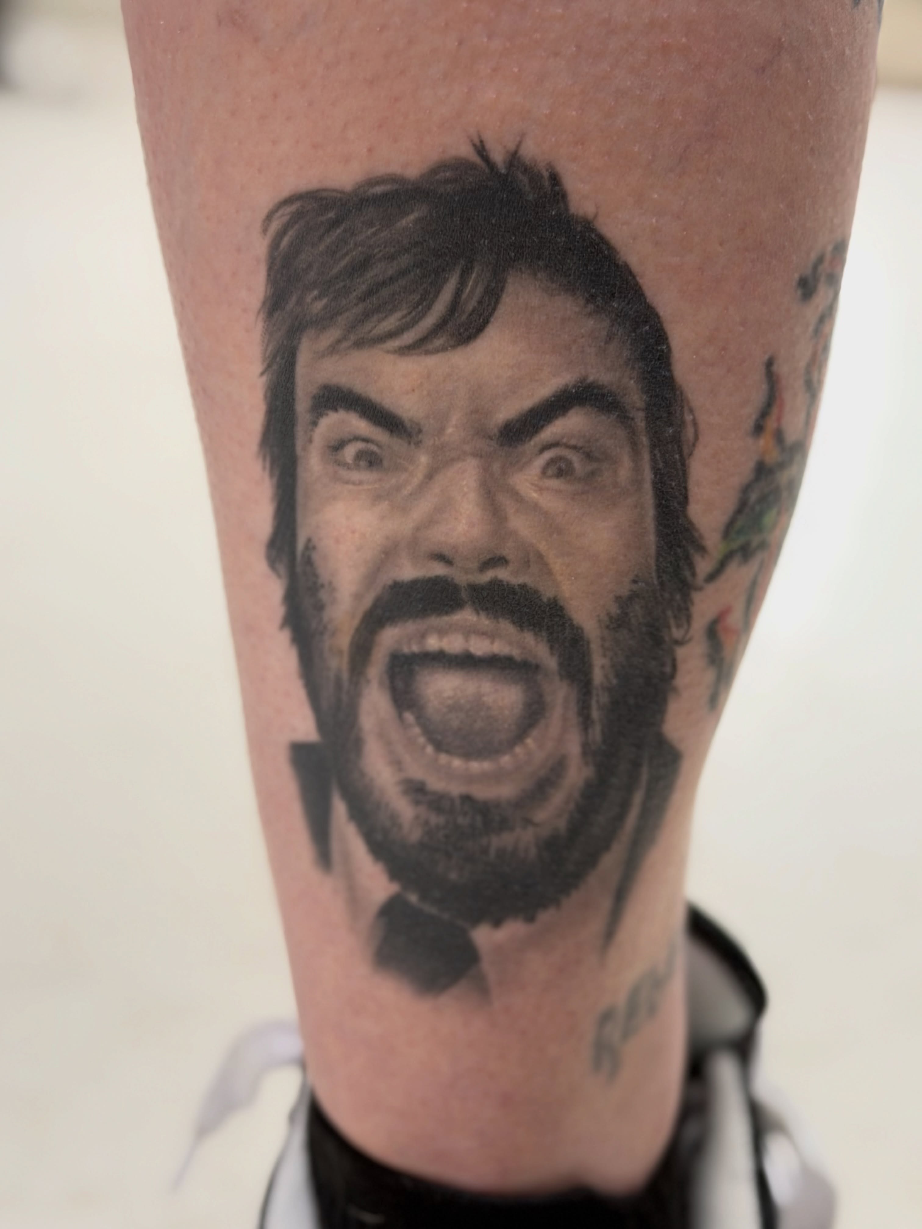 Angry man realism tattoo on the forearm by Cameron Mills - Tattoo artist
