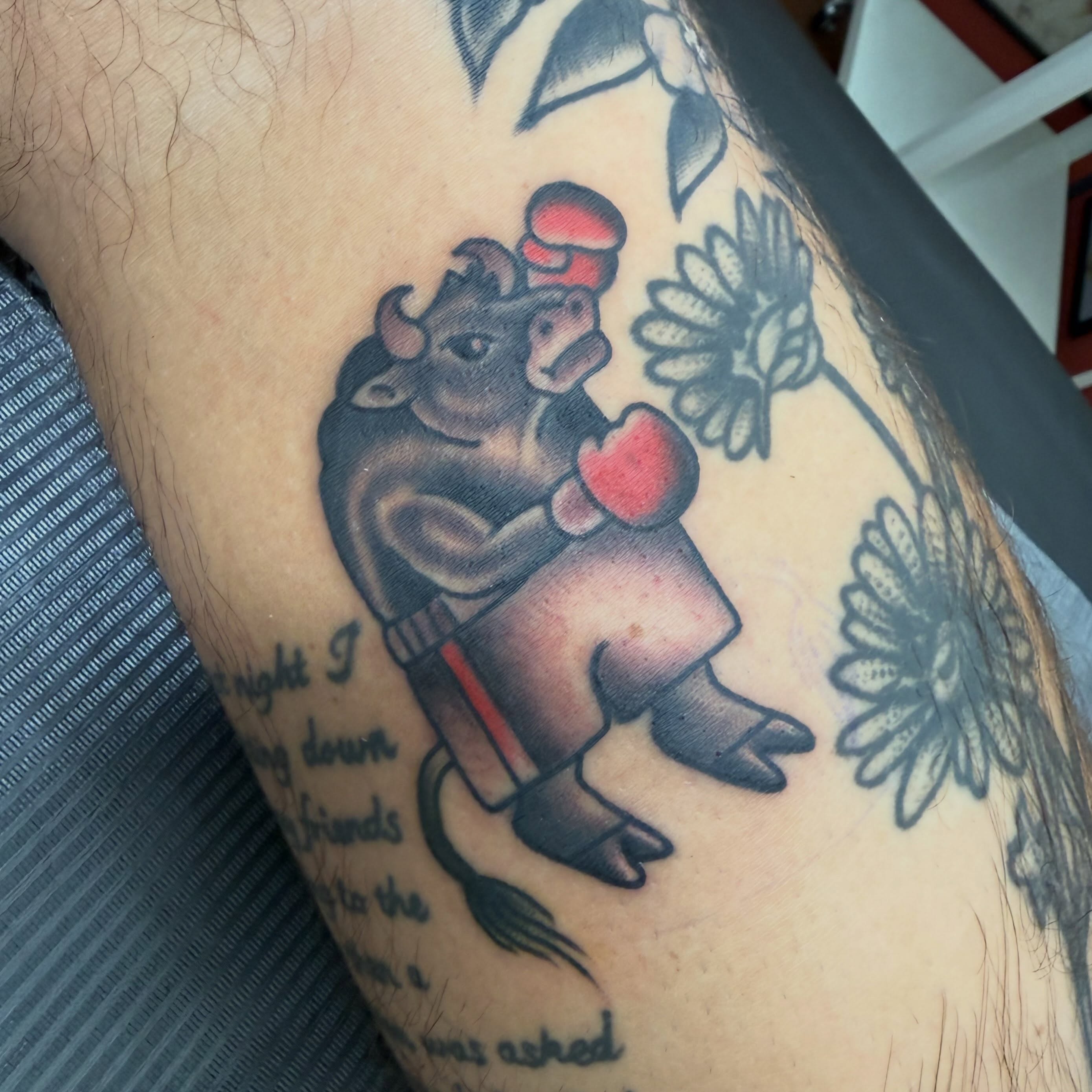 Bull with boxing gloves American traditional tattoo on the upper arm by Cody Dalton
