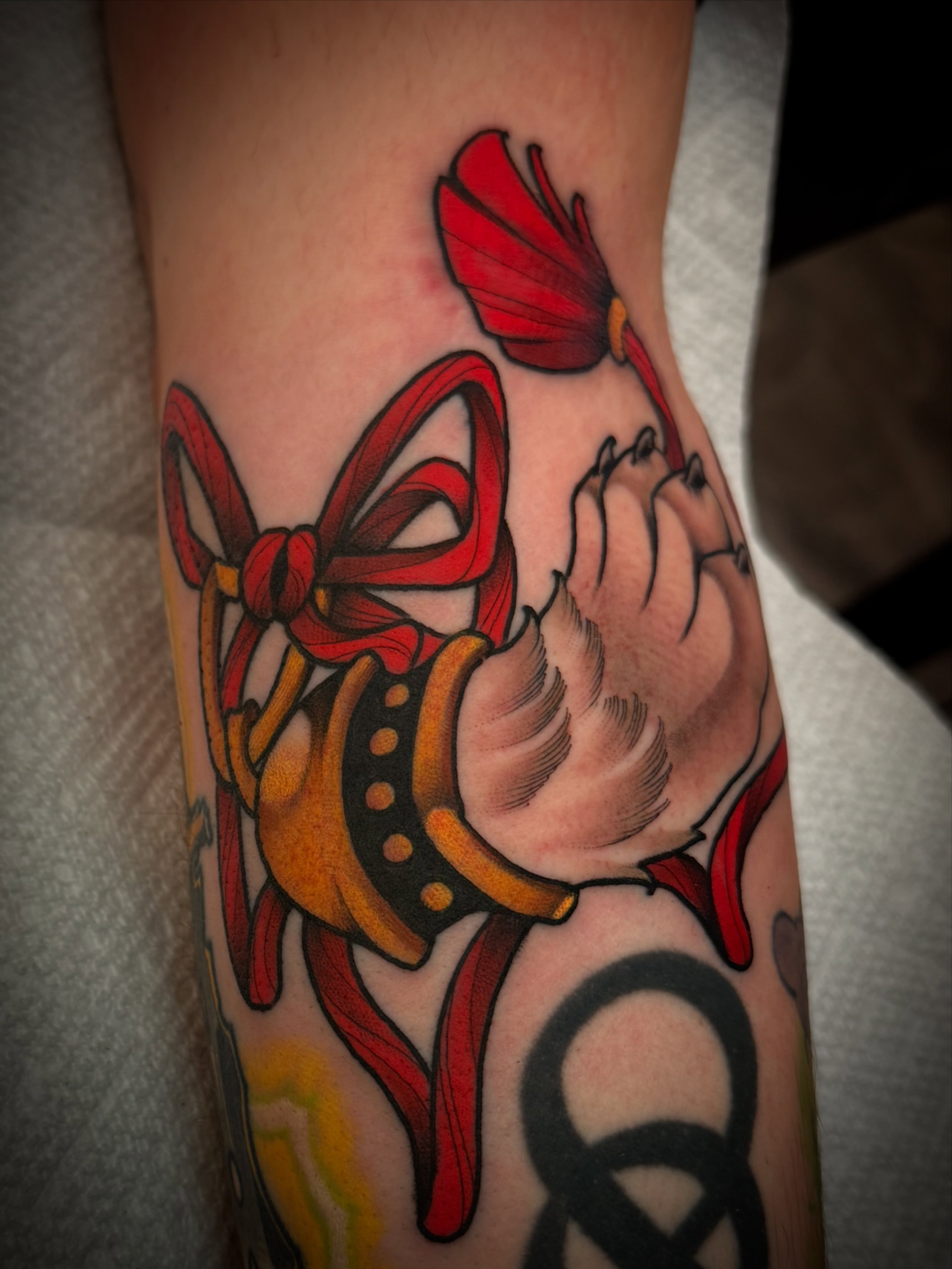 Red bow and flower American traditional tattoo on the forearm by Dave Osrowitz