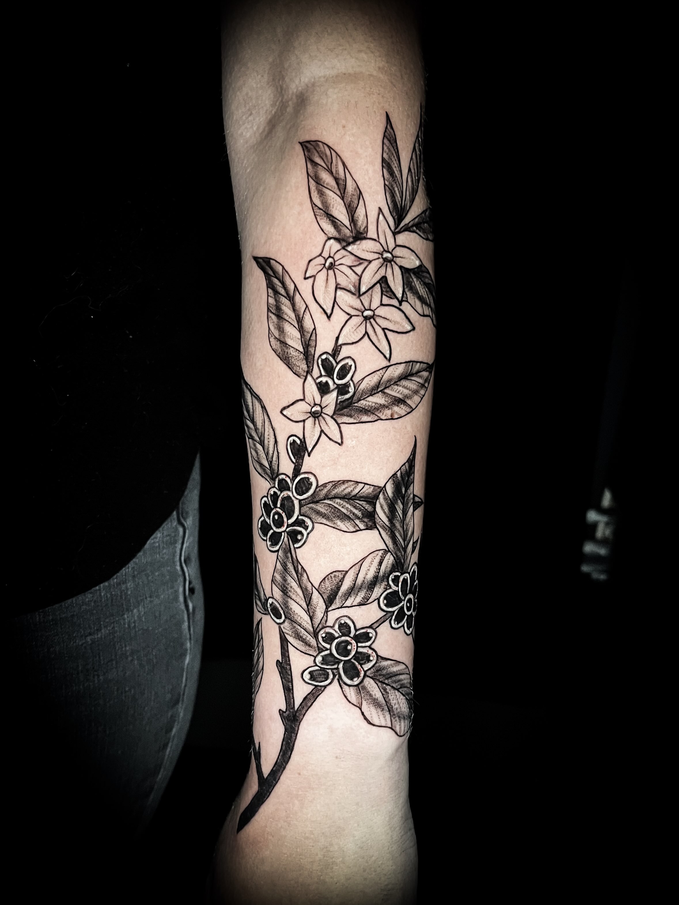 Flower branch black and grey tattoo on the forearm by Lindsay Fernandez, Colorado Springs, Colorado