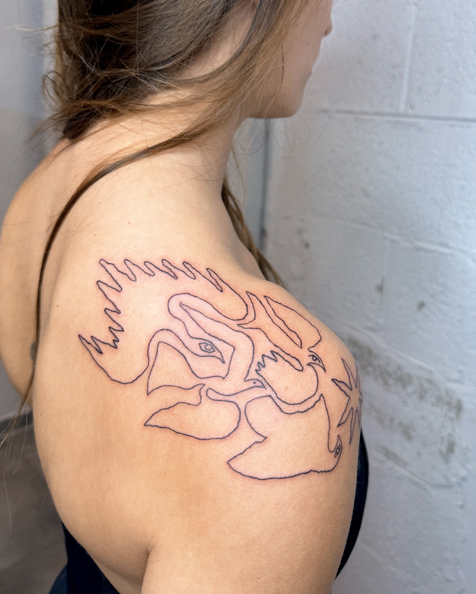 Abstract dragon geometric tattoo on the shoulder by Eden Kalif