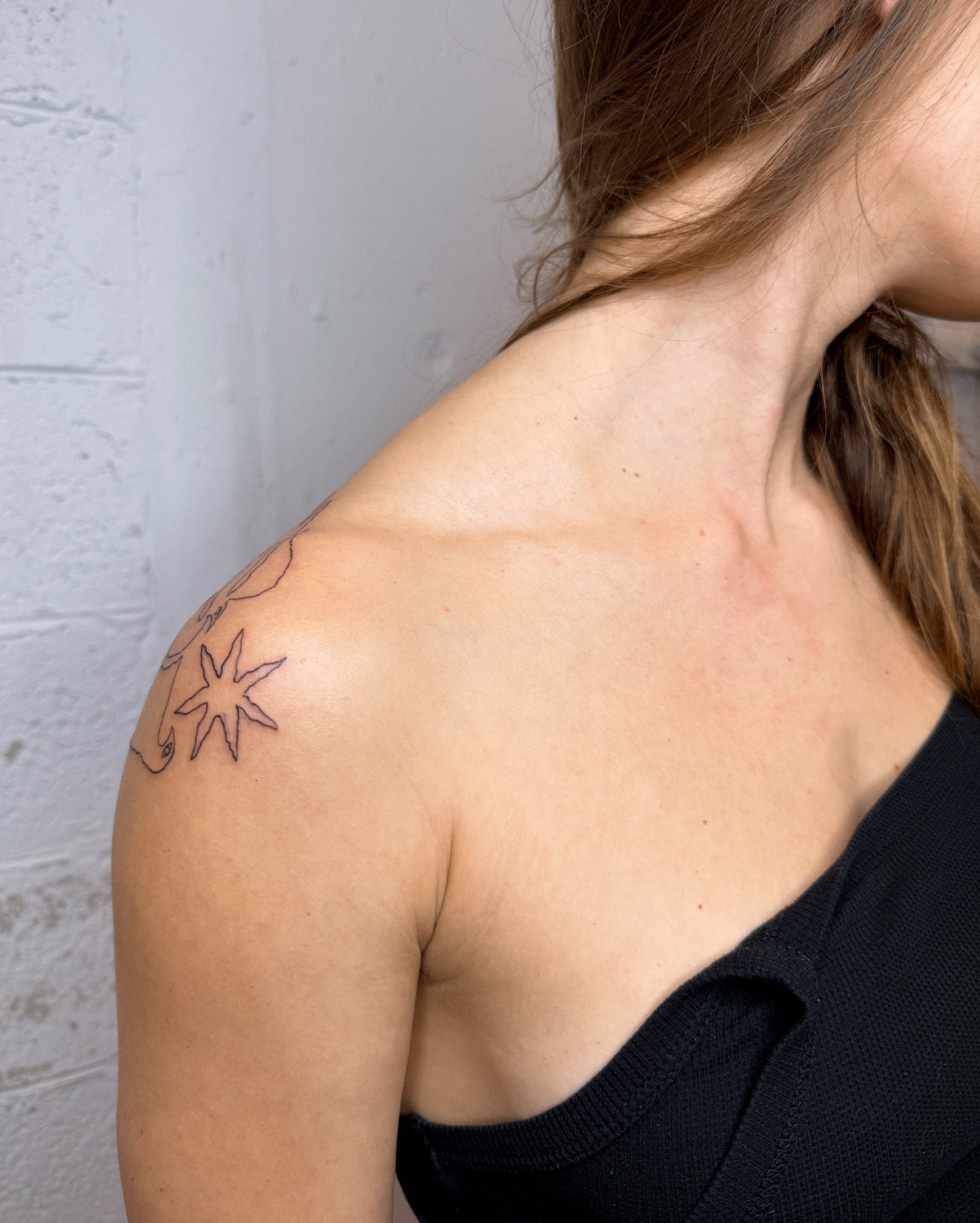 Star fine line tattoo on the shoulder by Eden Kalif