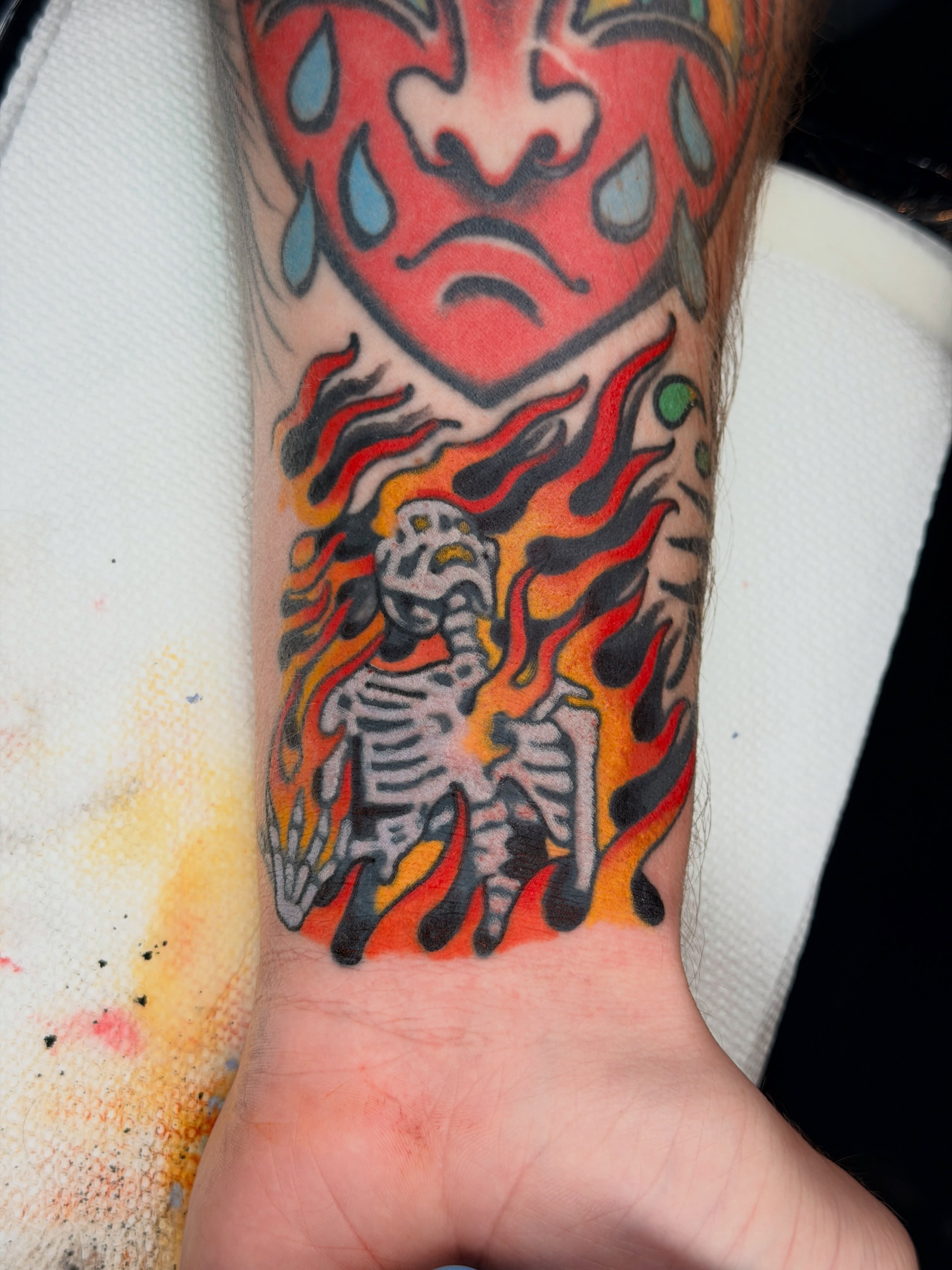 Flaming skeleton American traditional tattoo on the forearm by ๐๐ซ๐ข๐ ๐๐ฅ๐ญ๐จ๐ง๐๐ง
