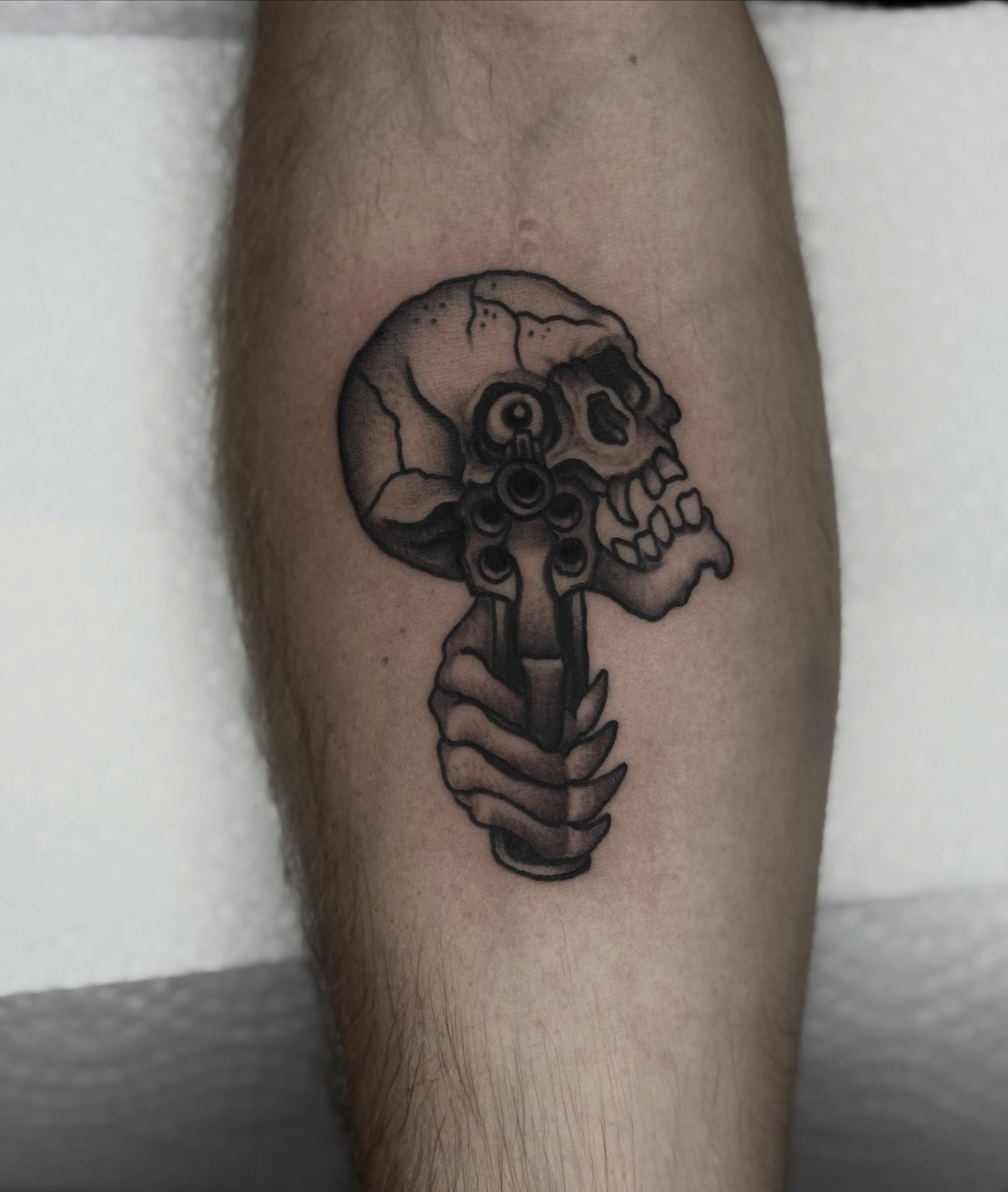 Skull and revolver black and grey tattoo on the forearm by Domanick Libretti, Nashville, Tennessee