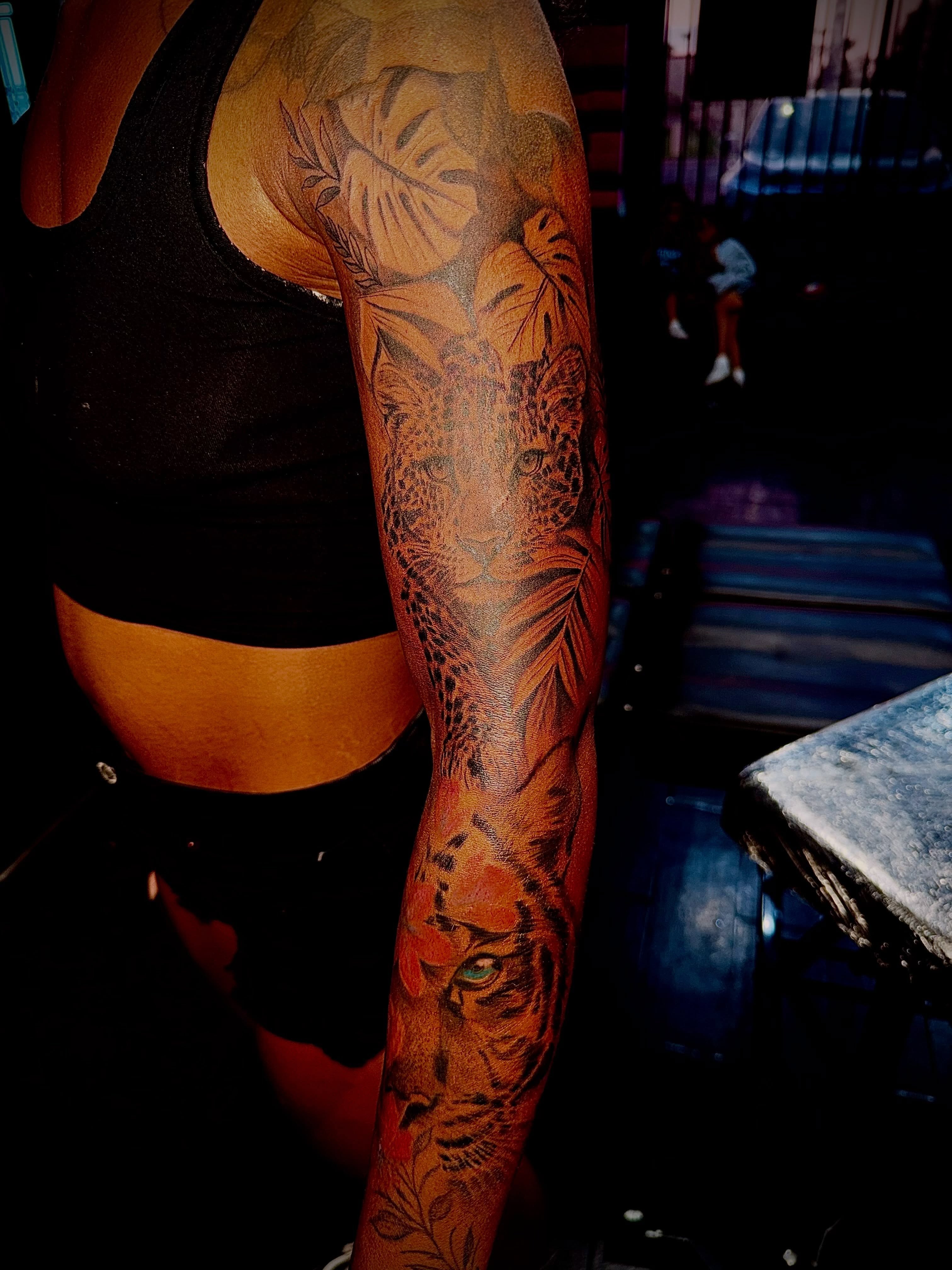 Tiger and foliage realism tattoo on the forearm by Clifford Jordan
