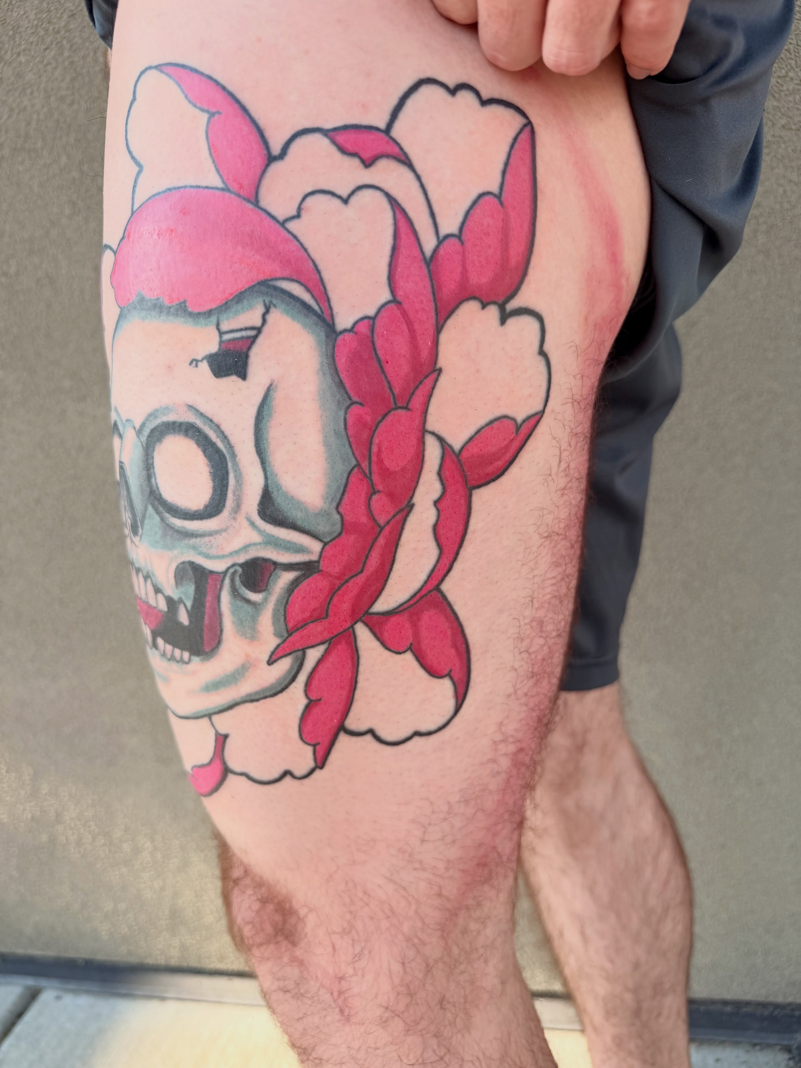 Skull with flowers American traditional tattoo on the thigh by Ellari