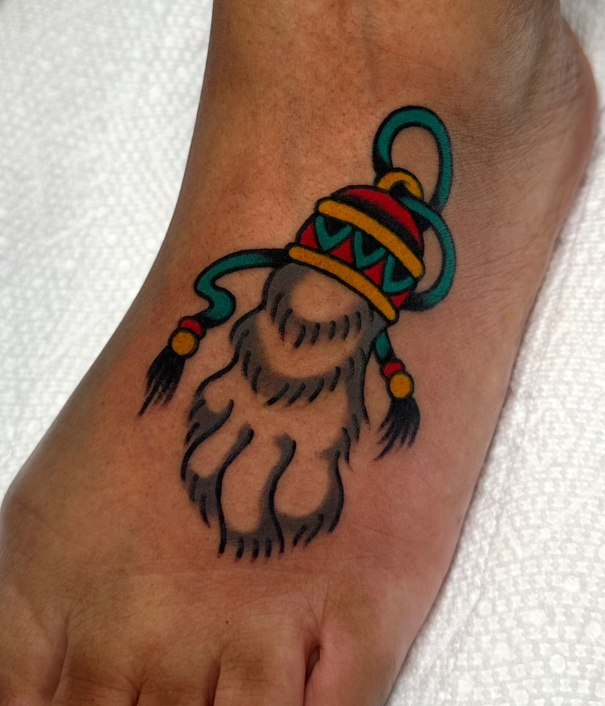 Bear paw with hat American traditional tattoo on the foot by Zahra Niedermann