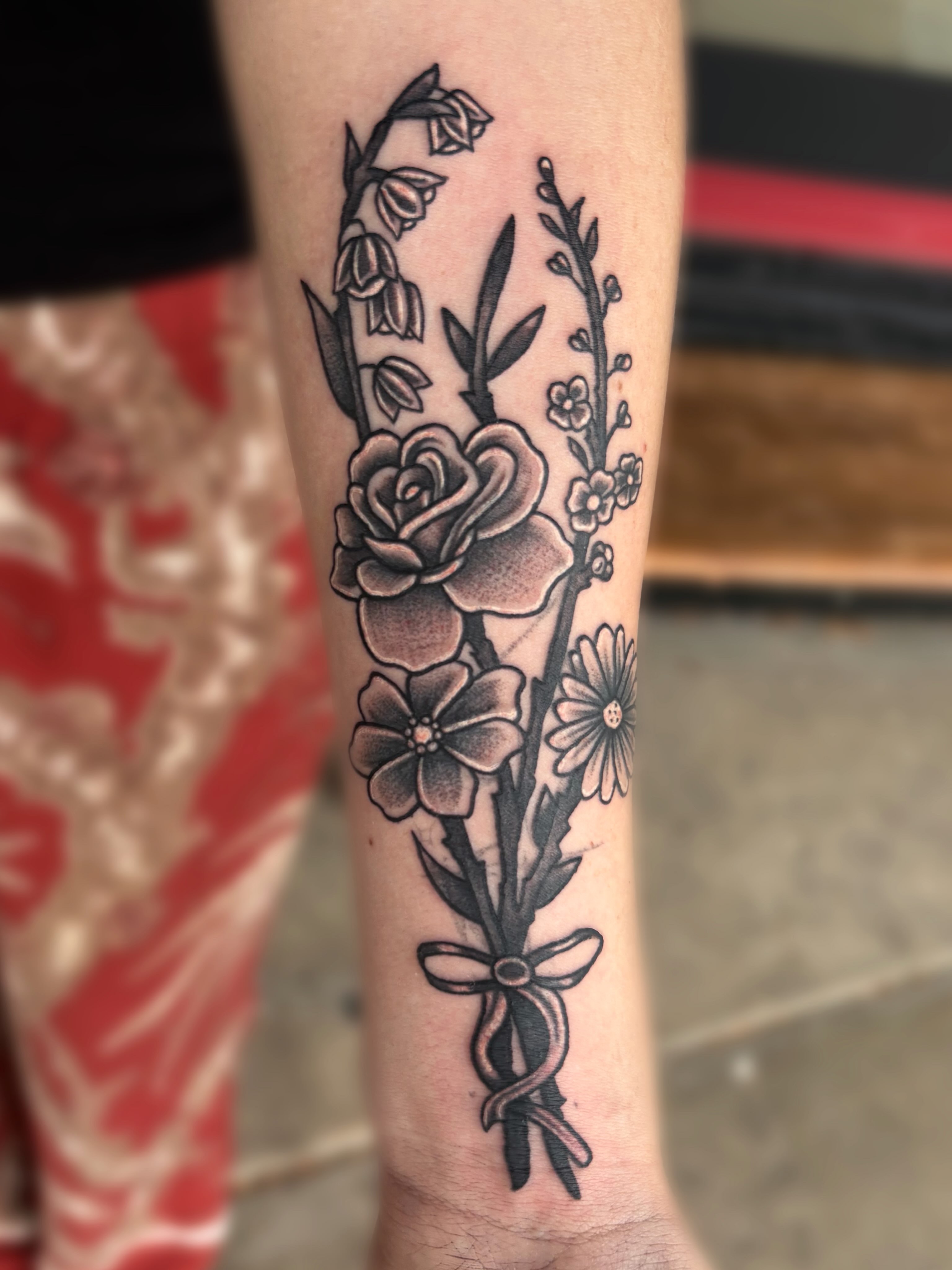 Flower bouquet black and grey tattoo on the forearm by Ava Brady Tattoos