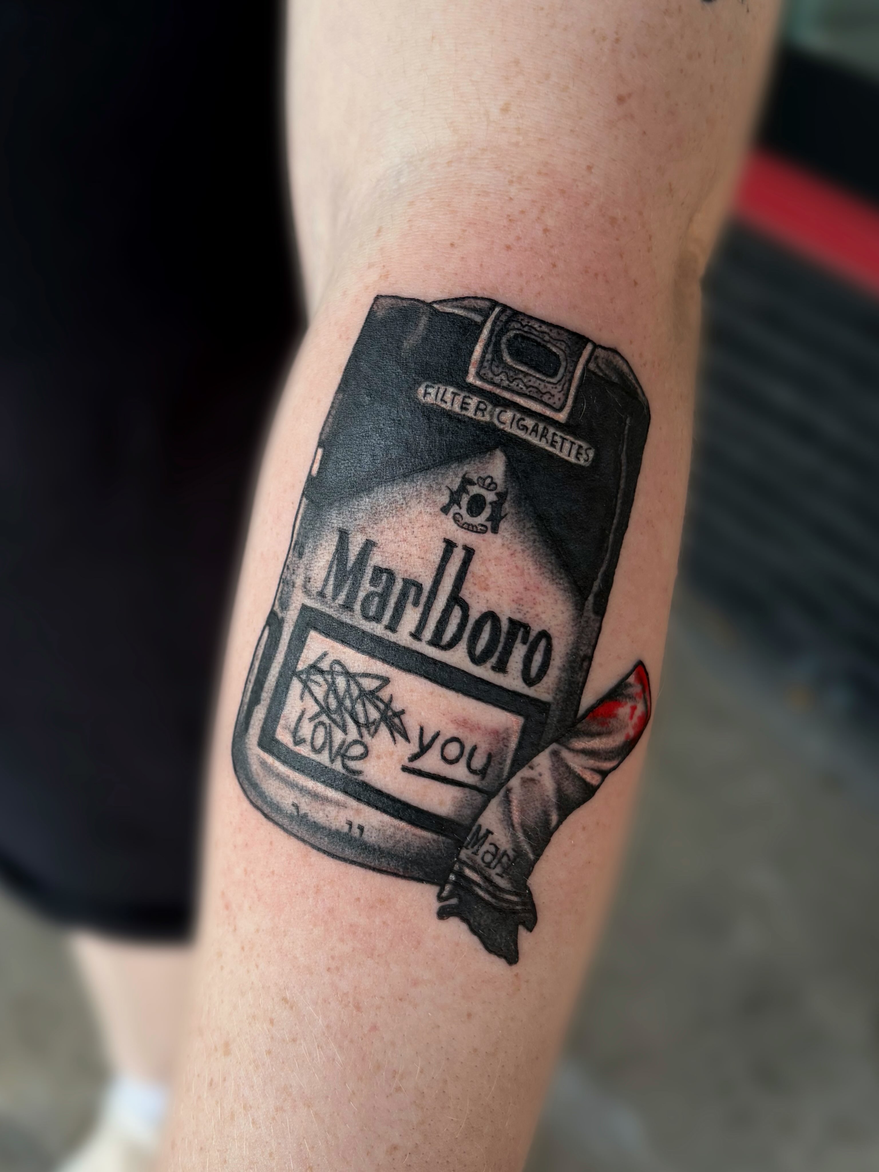Marlboro cigarette pack black and grey tattoo on the forearm by Ava Brady Tattoos