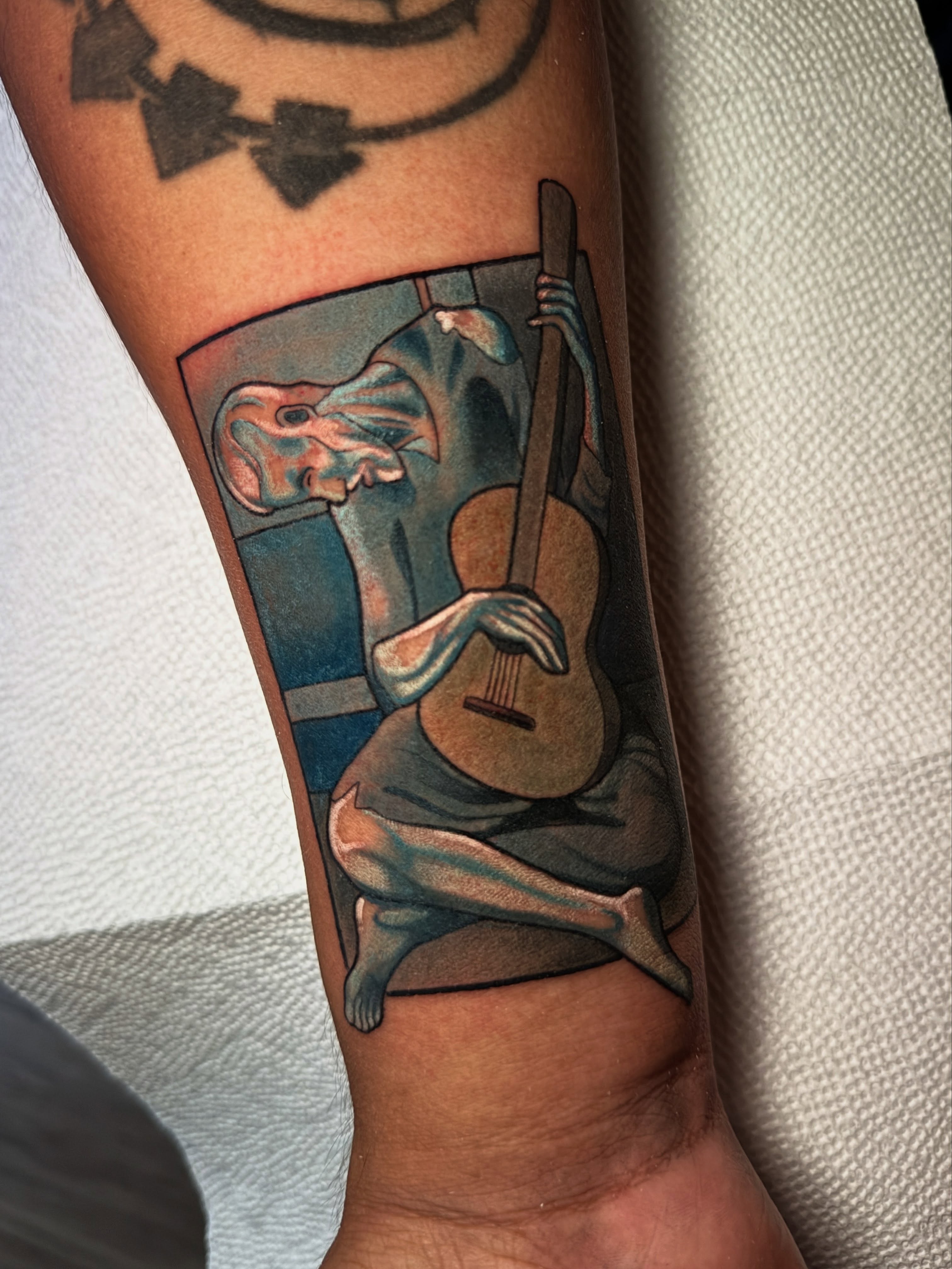 Guitar player realism tattoo on the forearm by Skye Kimball