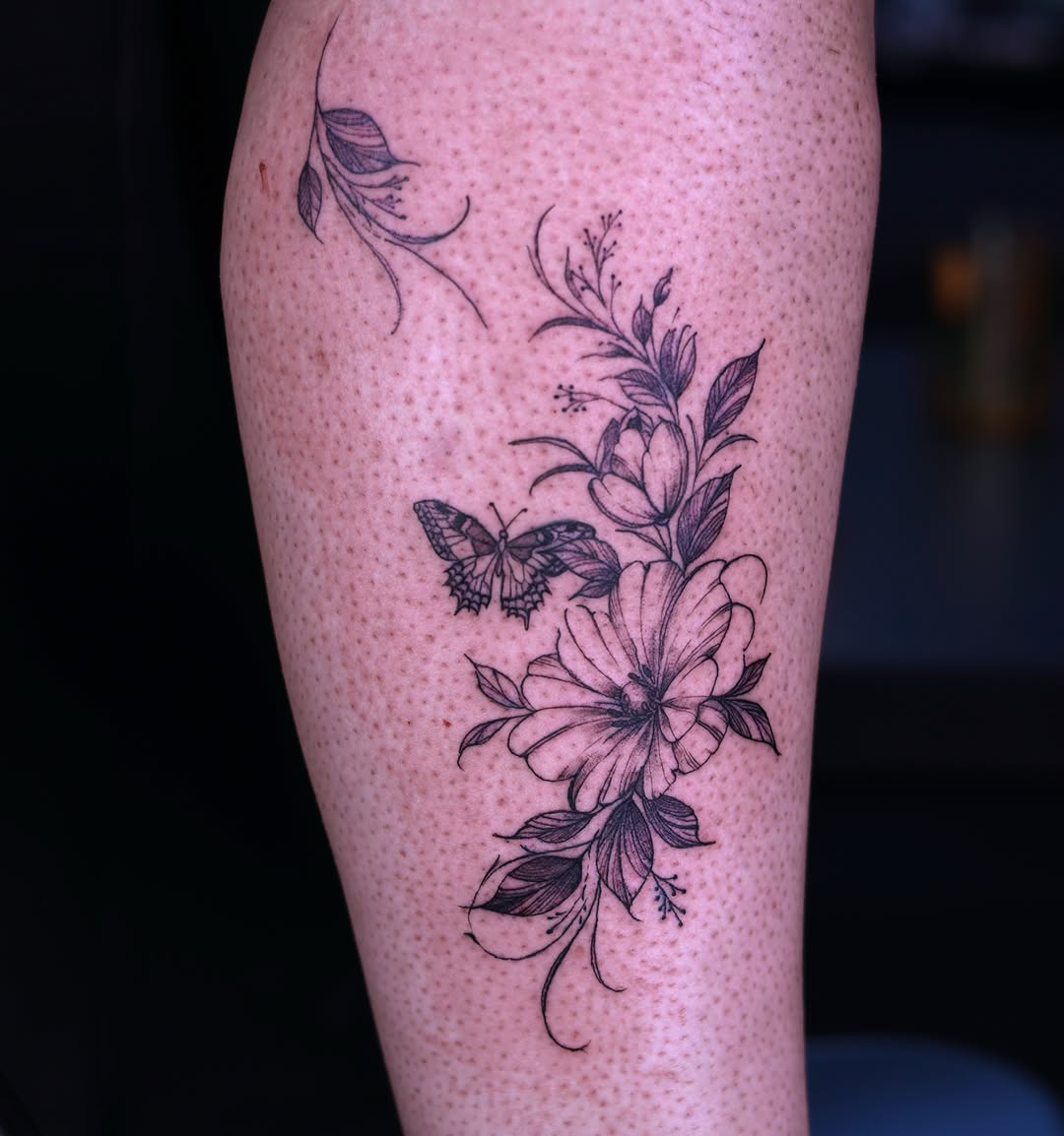 Flower and butterfly black and grey tattoo on the forearm by Tetiana