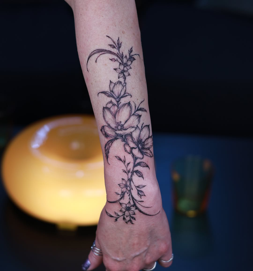 Floral vine black and grey tattoo on the forearm by Tetiana
