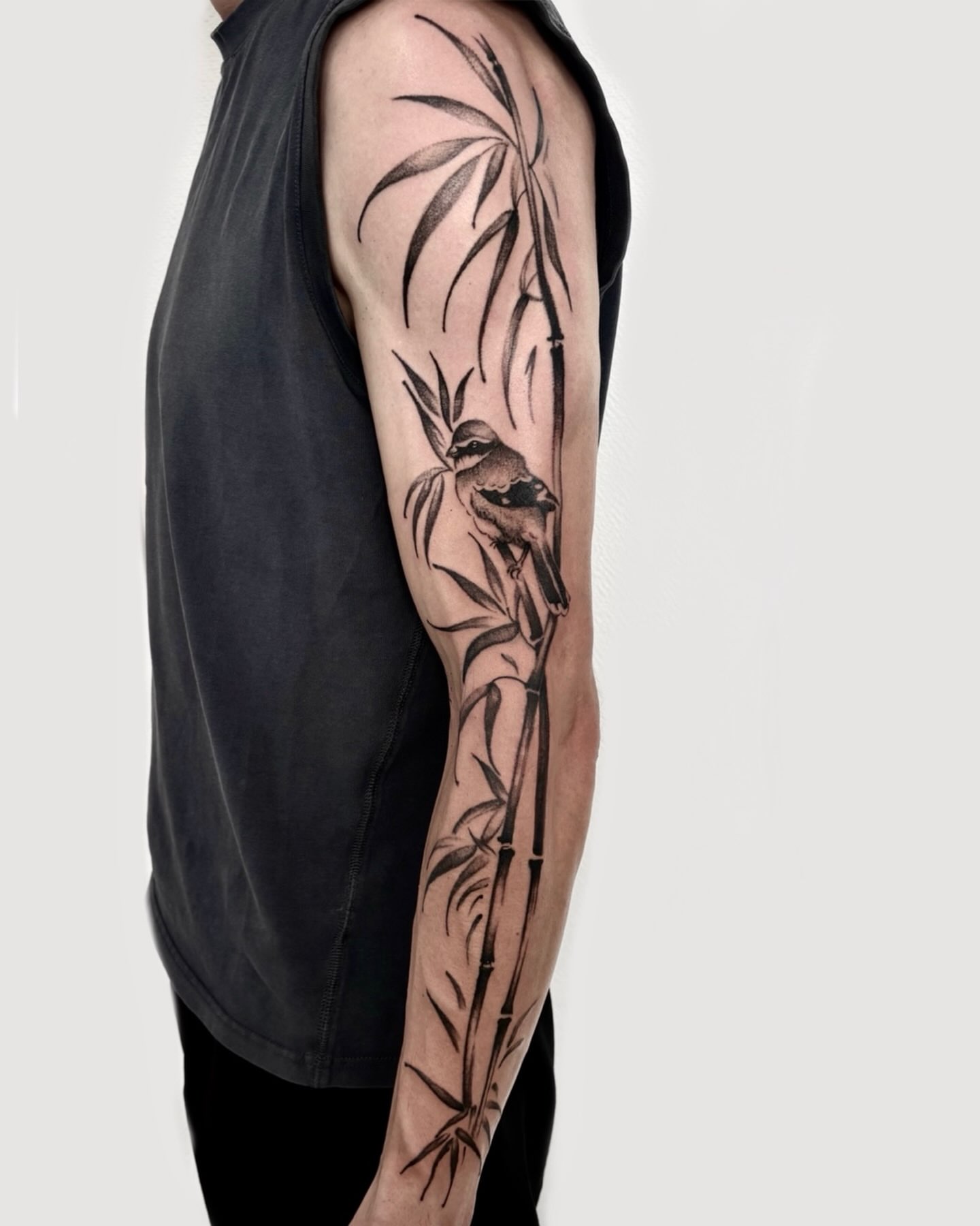 Bird and bamboo black and grey tattoo on the forearm by Deborah