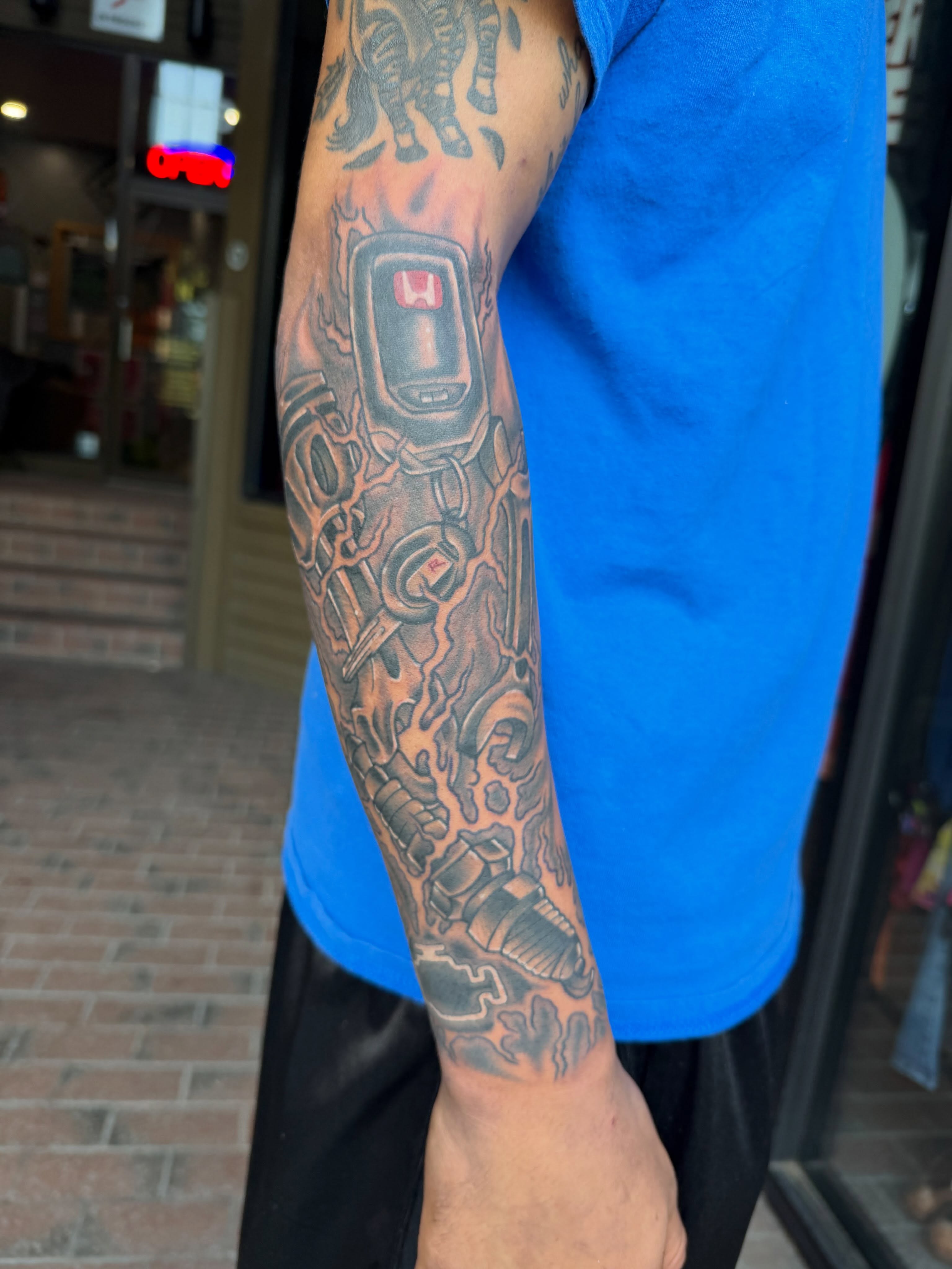 Car key black and grey tattoo on the forearm by Mike Lachowicz
