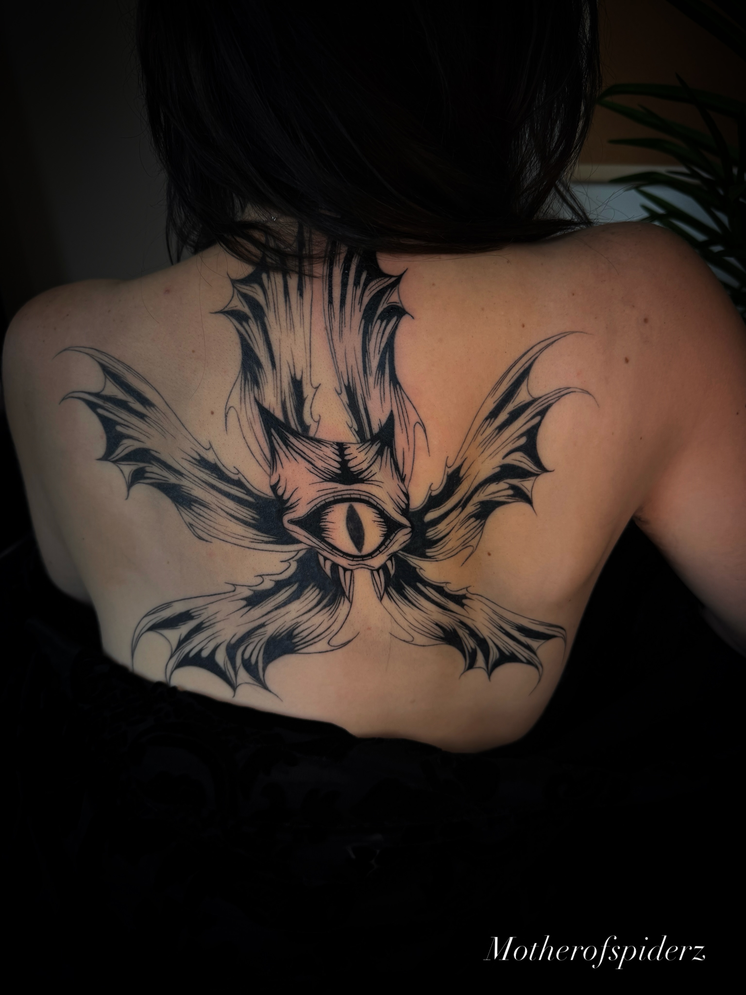 Eye with bat wings geometric tattoo on the back by Alyssa Garza