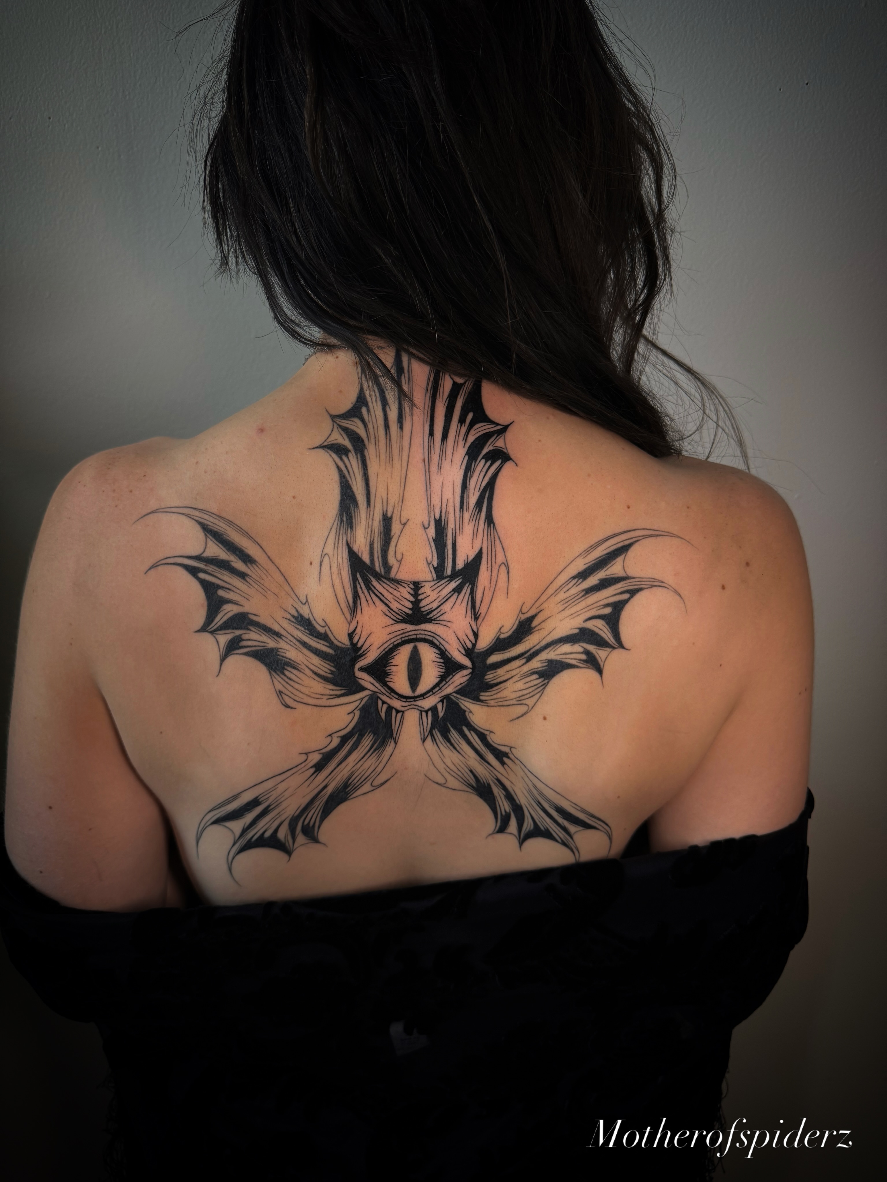 Eye with bat wings dark realism tattoo on the back by Alyssa Garza