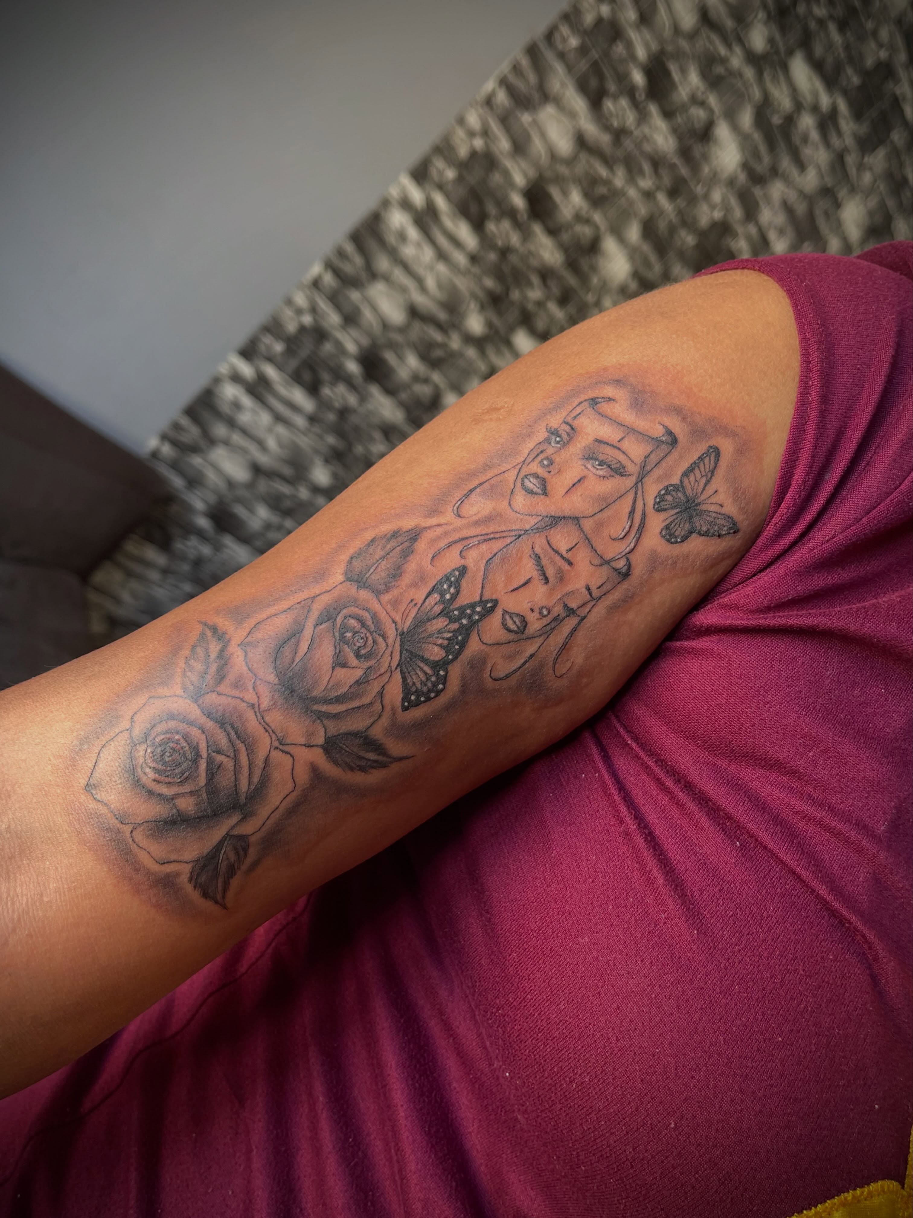 Woman with roses and butterflies black and grey tattoo on the forearm by Tu SanchoTattoos