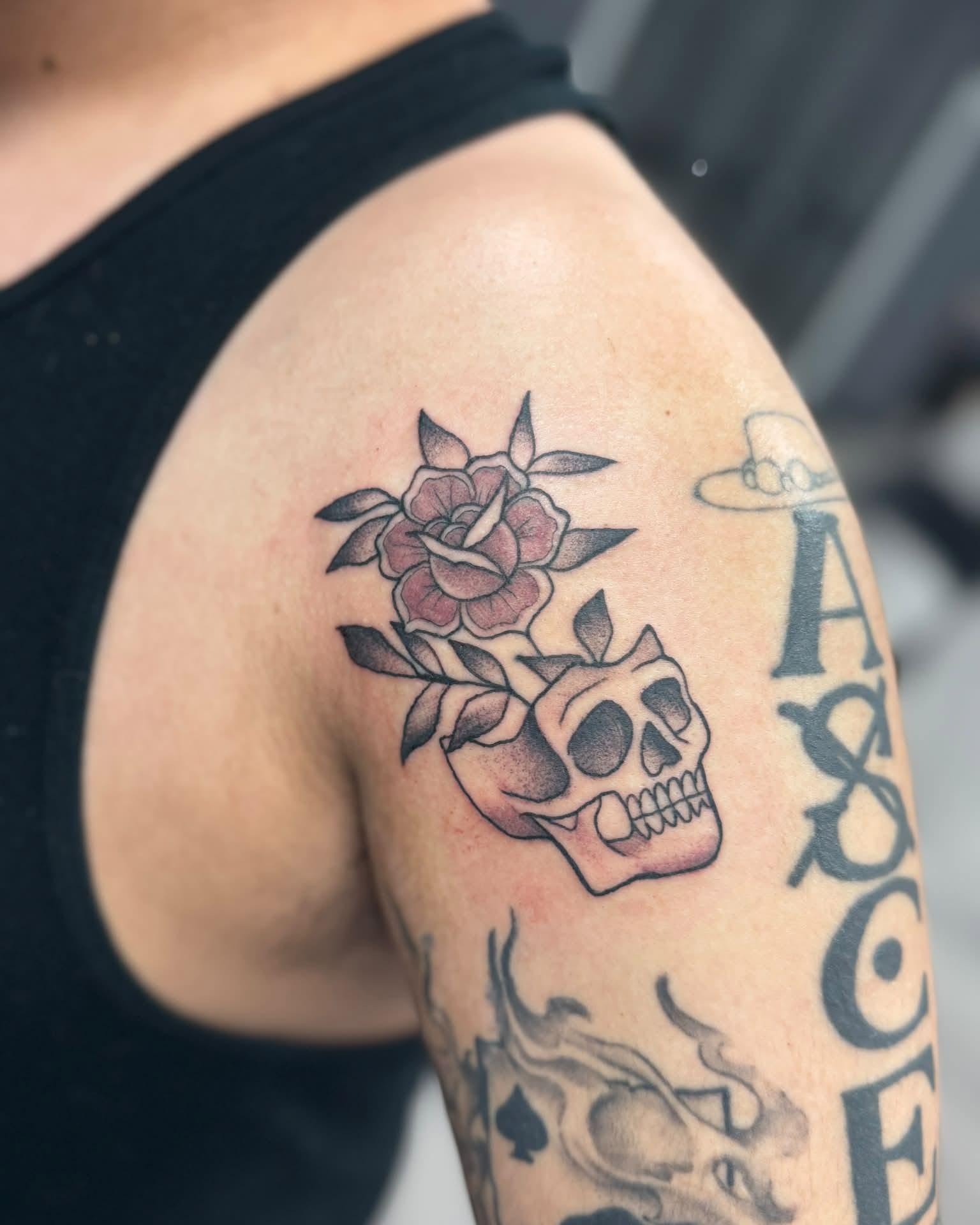 Skull and roses American traditional tattoo on the shoulder by Israel Jacob Woehler