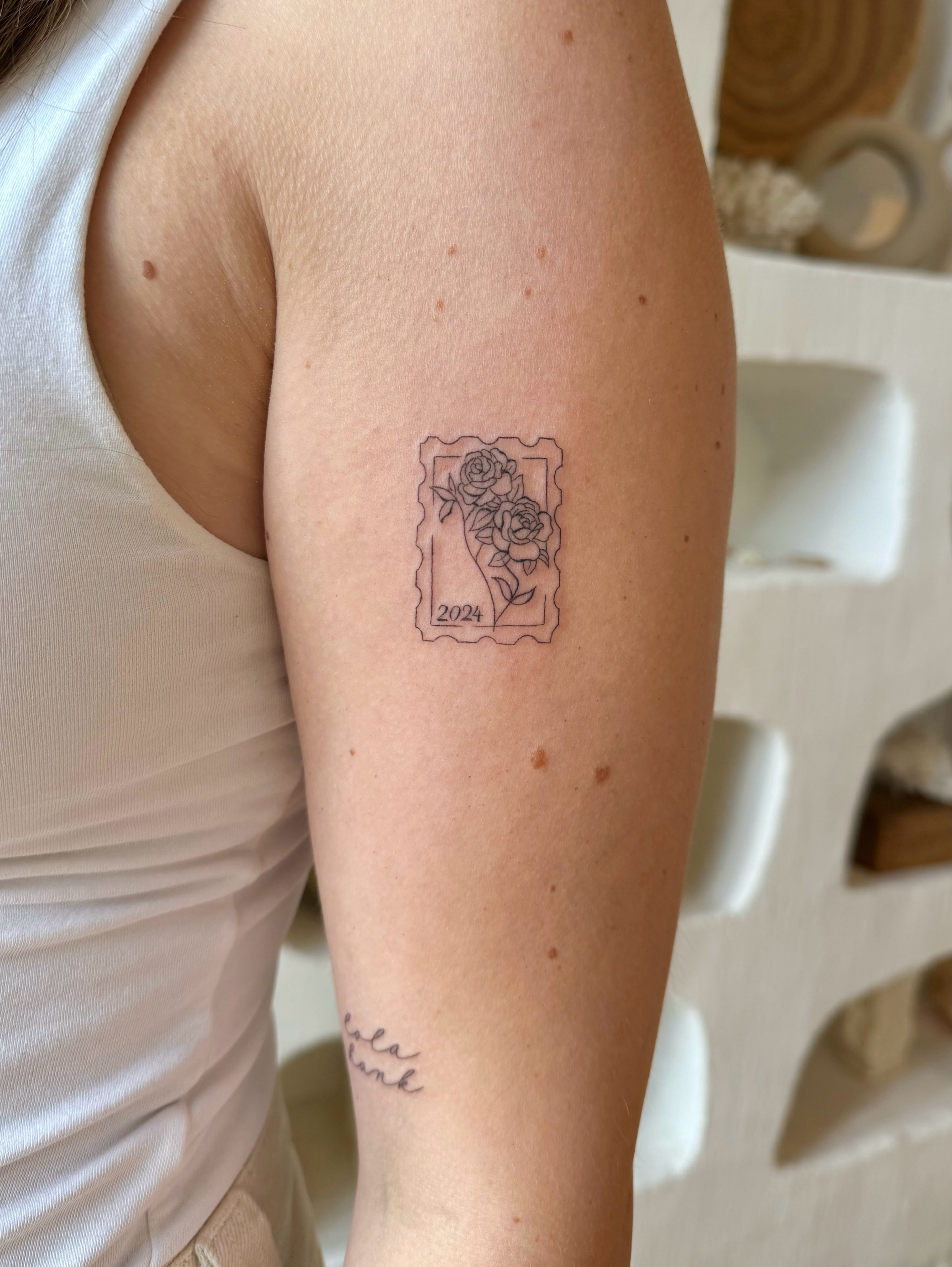 Flowers in a postage stamp black and grey tattoo on the forearm by Shilo Gold 🍒