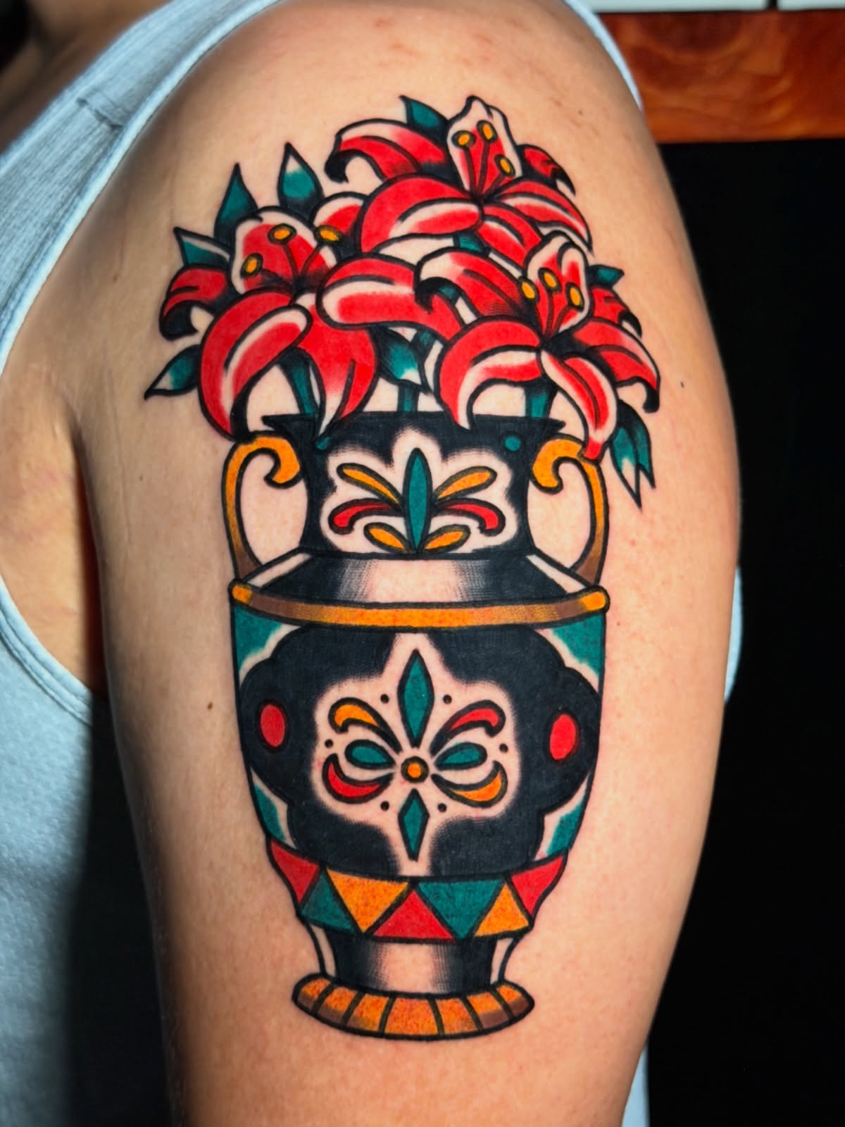 Lilies in vase American traditional tattoo on the shoulder by Kyle Dean Traditional Tattoo Artist