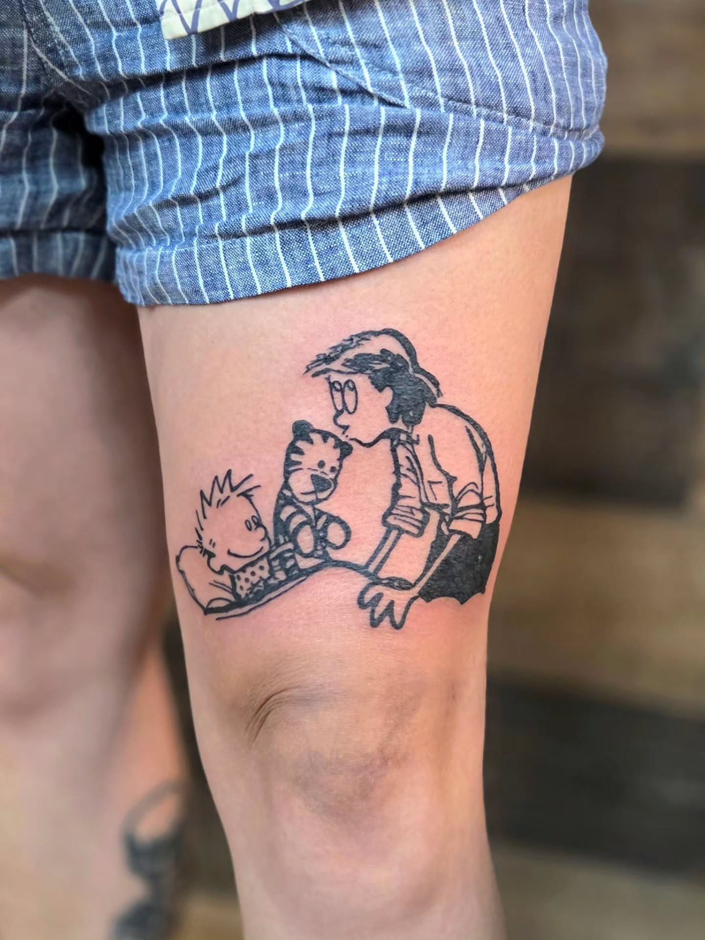 Calvin and Hobbes black and grey tattoo on the thigh by Courtney, Lakewood, Ohio