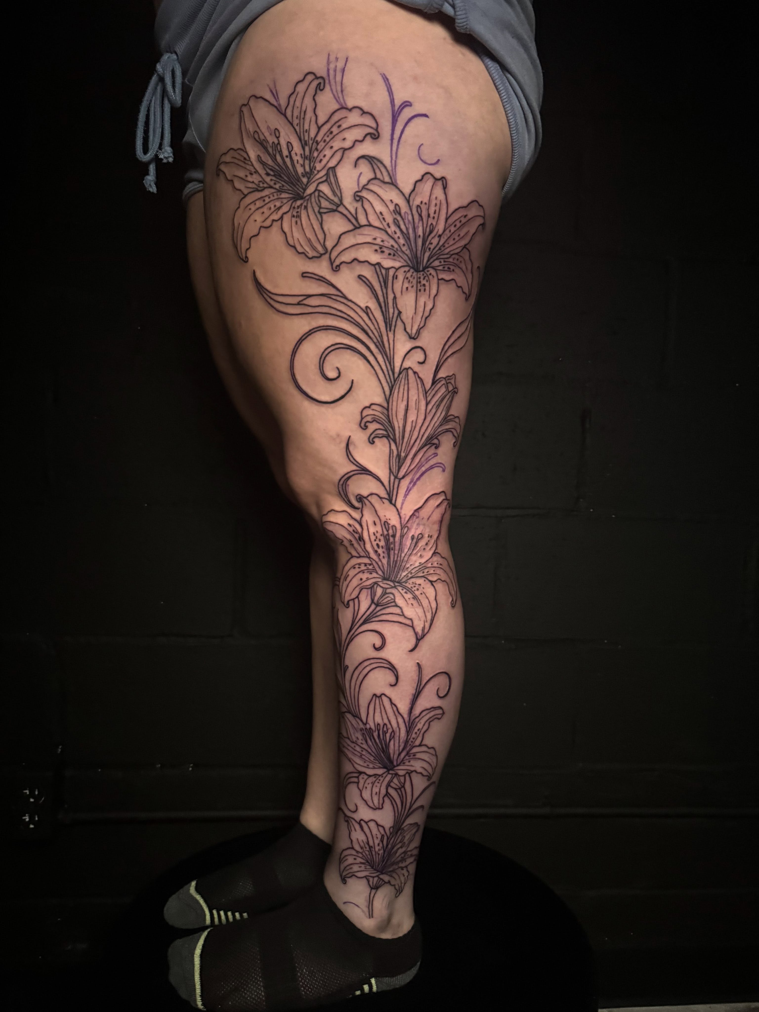 Lilies black and grey tattoo on the leg by Brandiane Wells