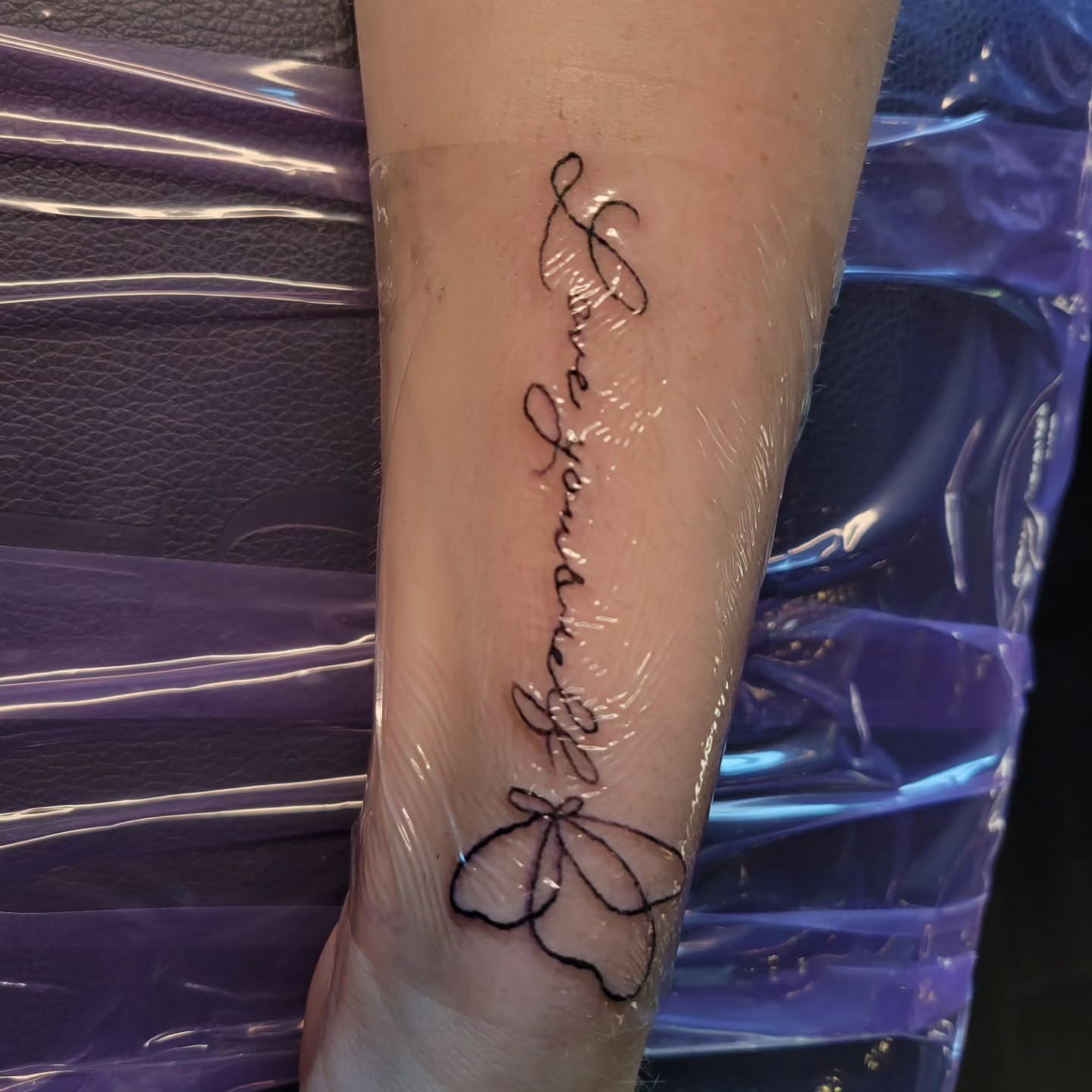 Love yourself lettering script tattoo on the forearm by Bee