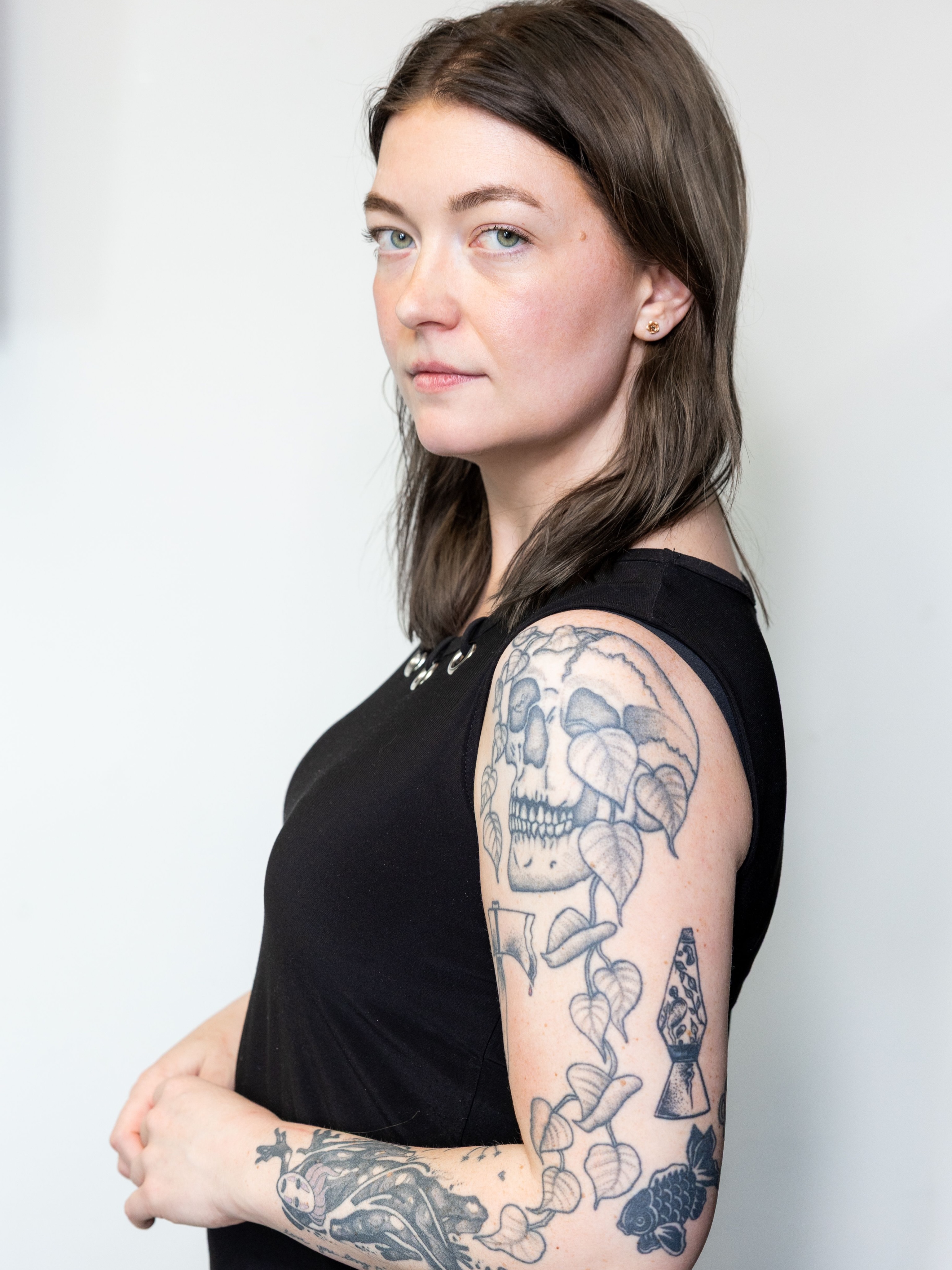 Skull and leaves black and grey tattoo on the upper arm by Rachel Hanke