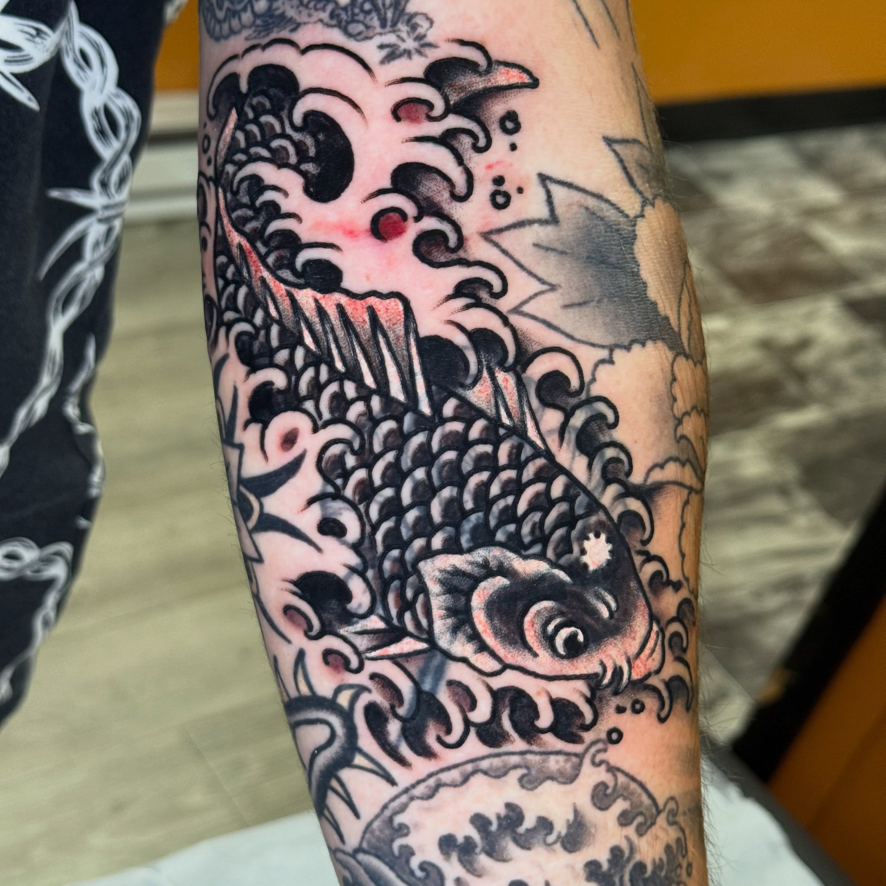 Koi fish American traditional tattoo on the forearm by Mike Dunn