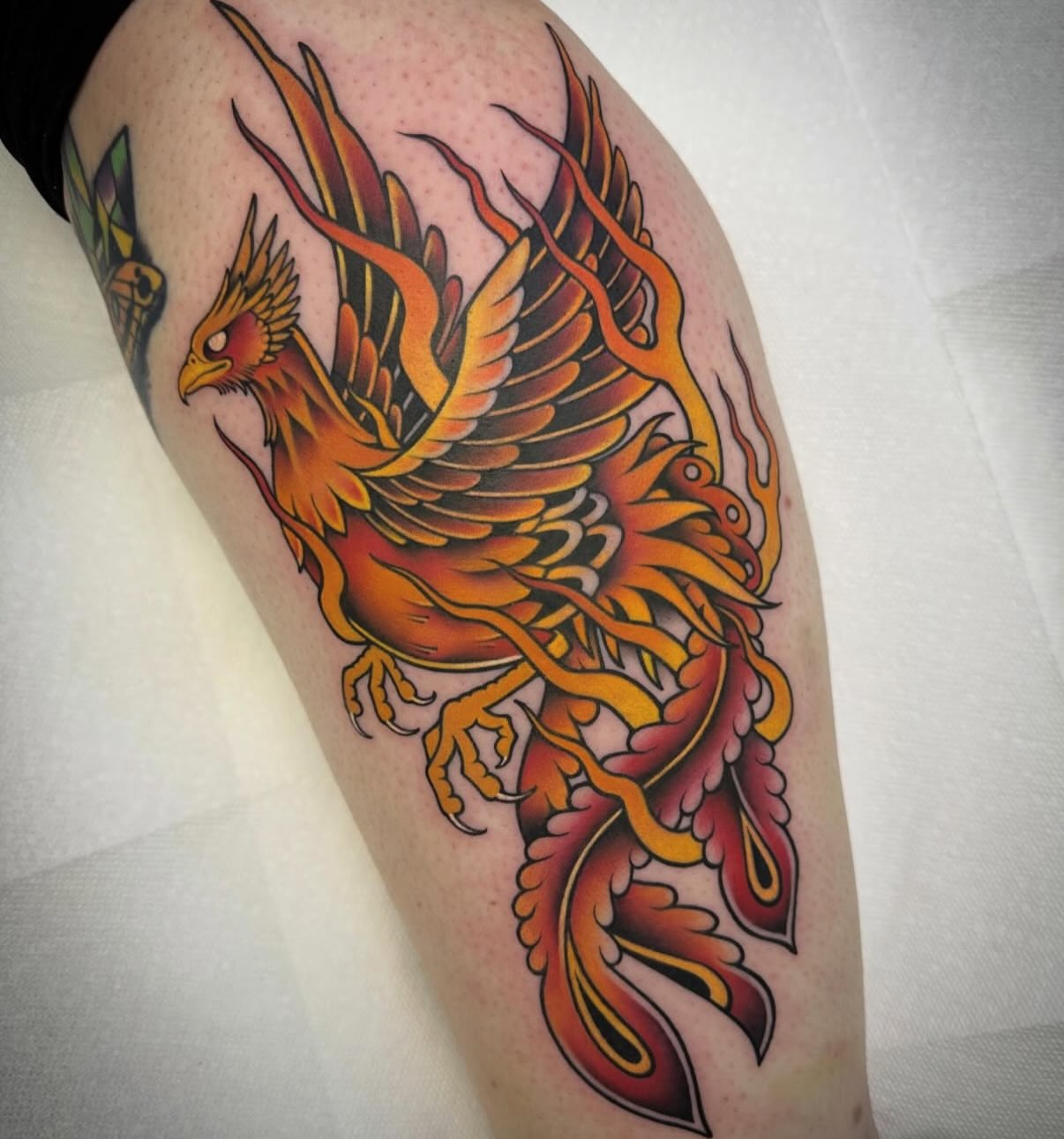 Phoenix American traditional tattoo on the thigh by Mark Boller