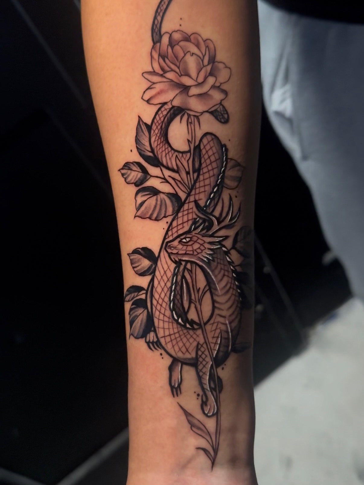 Dragon and flower American traditional tattoo on the forearm by Svetlana